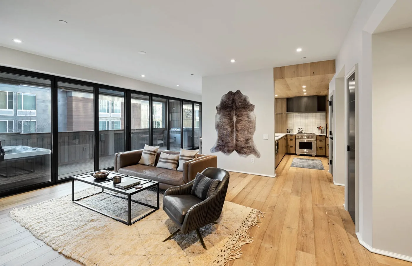 An open-plan living area with seating and a kitchen at the back.