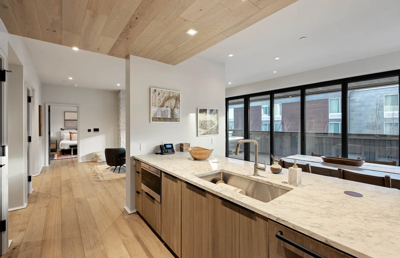 Una cocina moderna con una isla grande y ventanas junto al comedor.