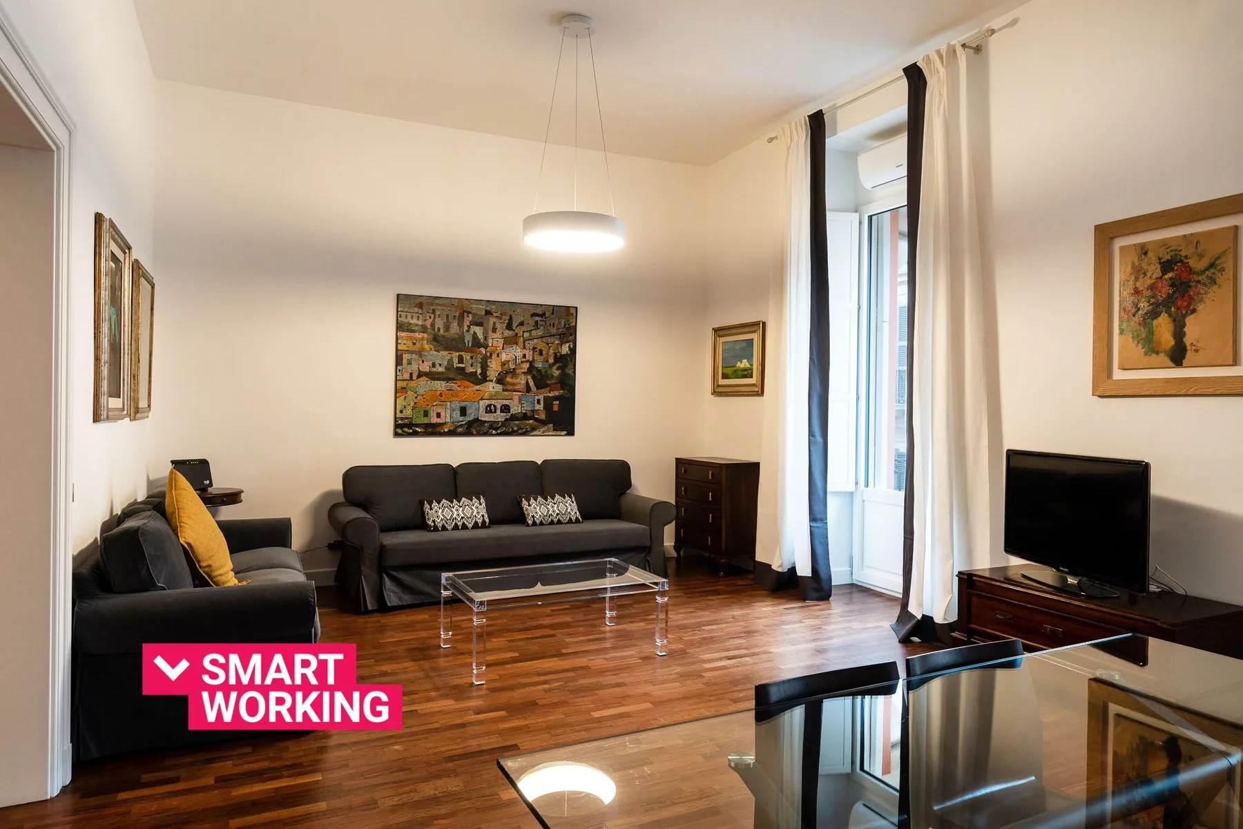Una sala de estar con asientos, una mesa de centro y un televisor.