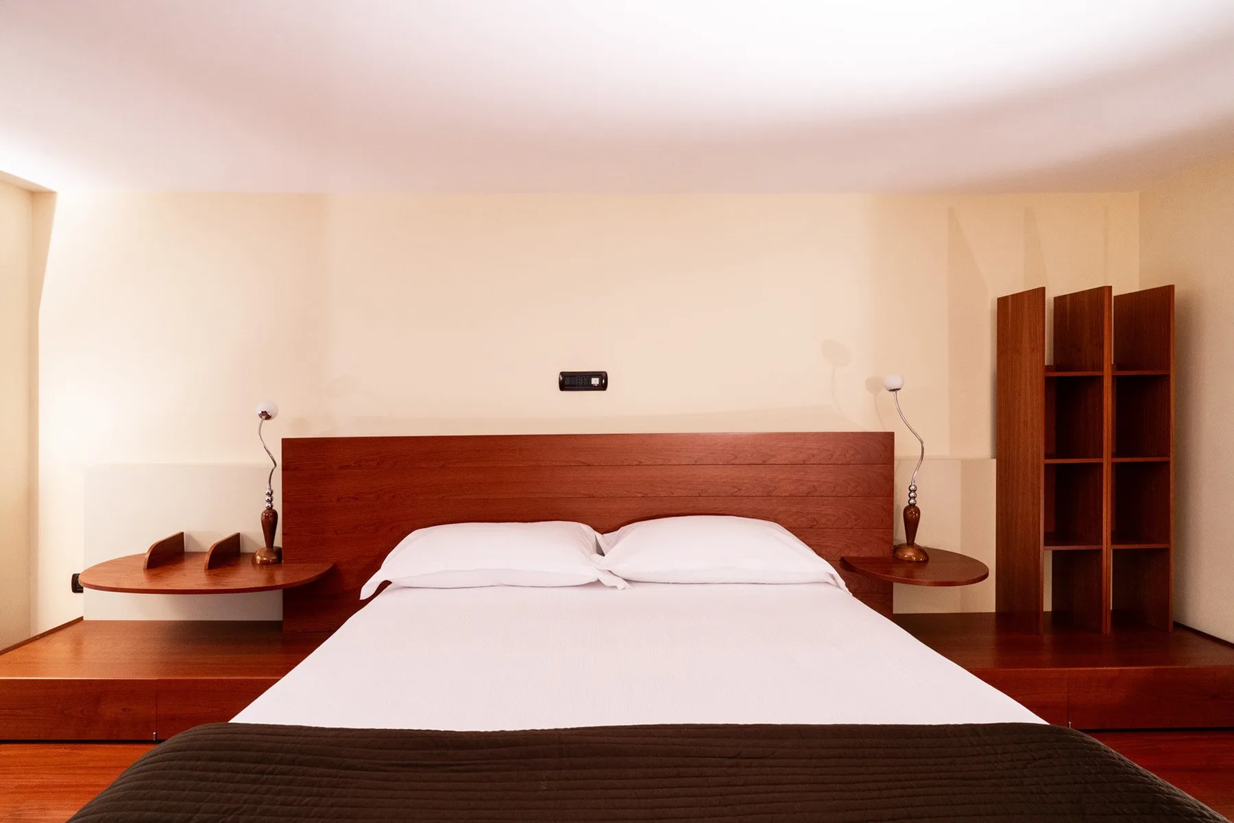 Un dormitorio con una cama bien tendida y un cabecero de madera.