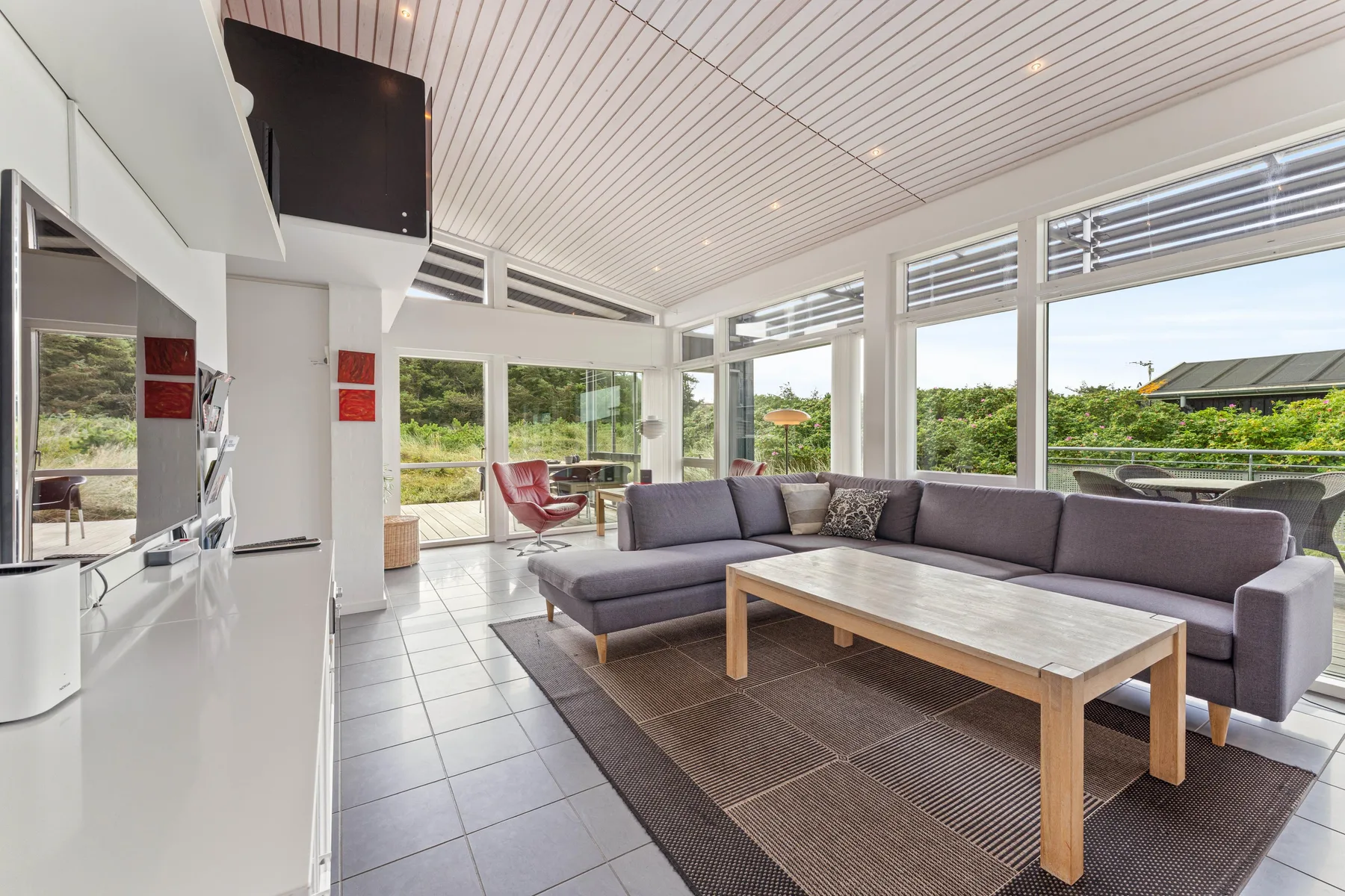 A bright living room with a sectional seating area and large windows.