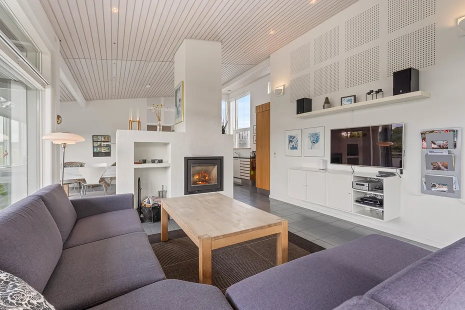 A bright living room with seating, a wooden coffee table, and a fireplace.