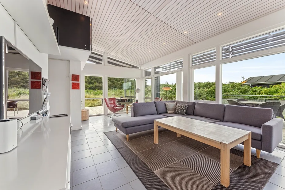 A bright living room with a sectional sofa and a wooden coffee table.