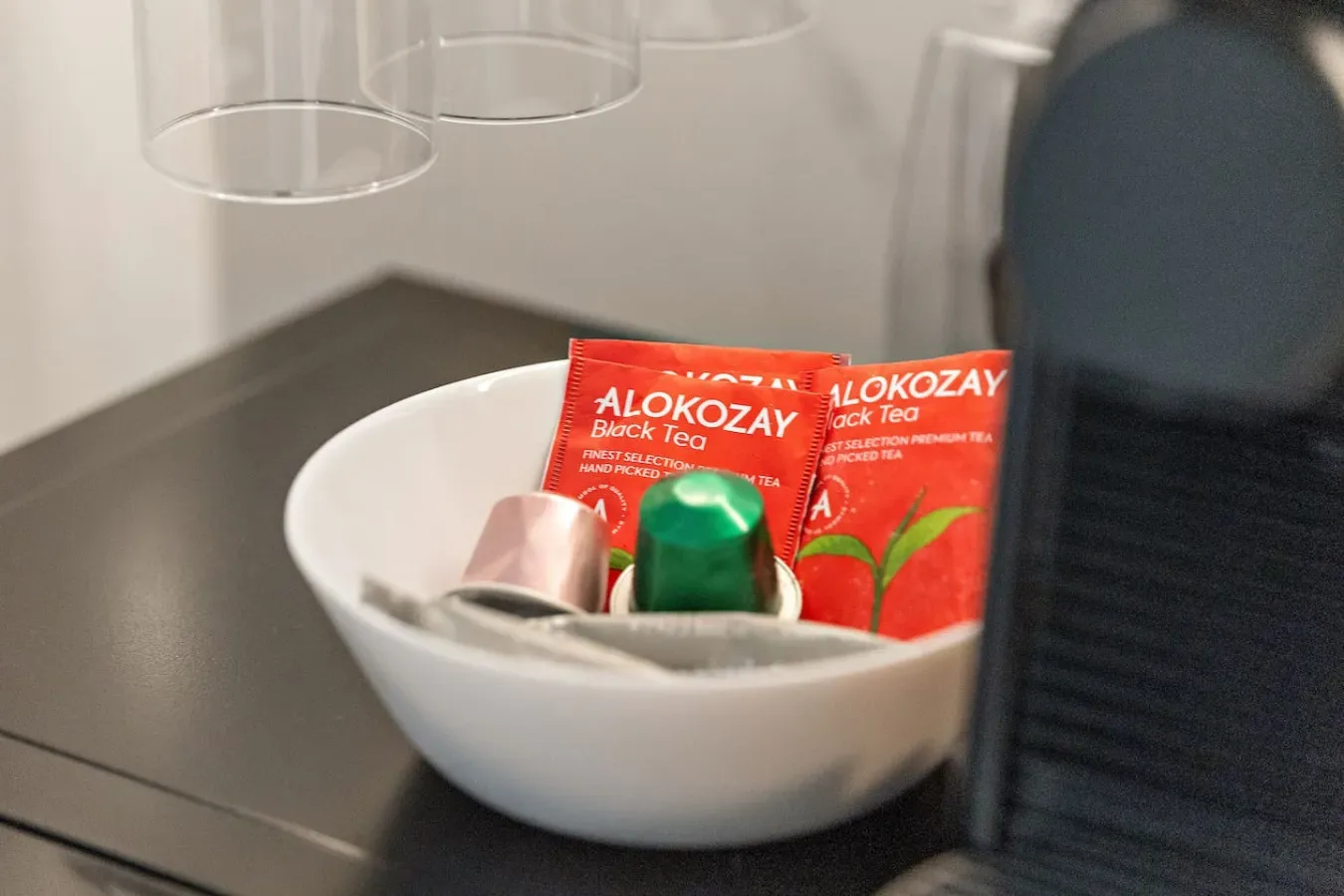 A countertop bowl holds tea packets and small toiletries.