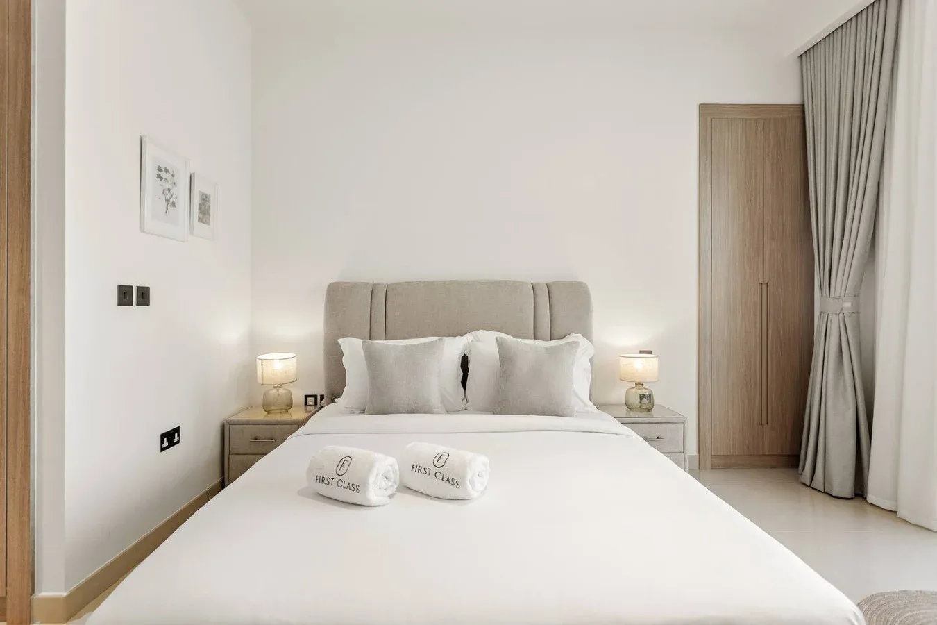 A bedroom with a neatly made bed and bedside lamps.