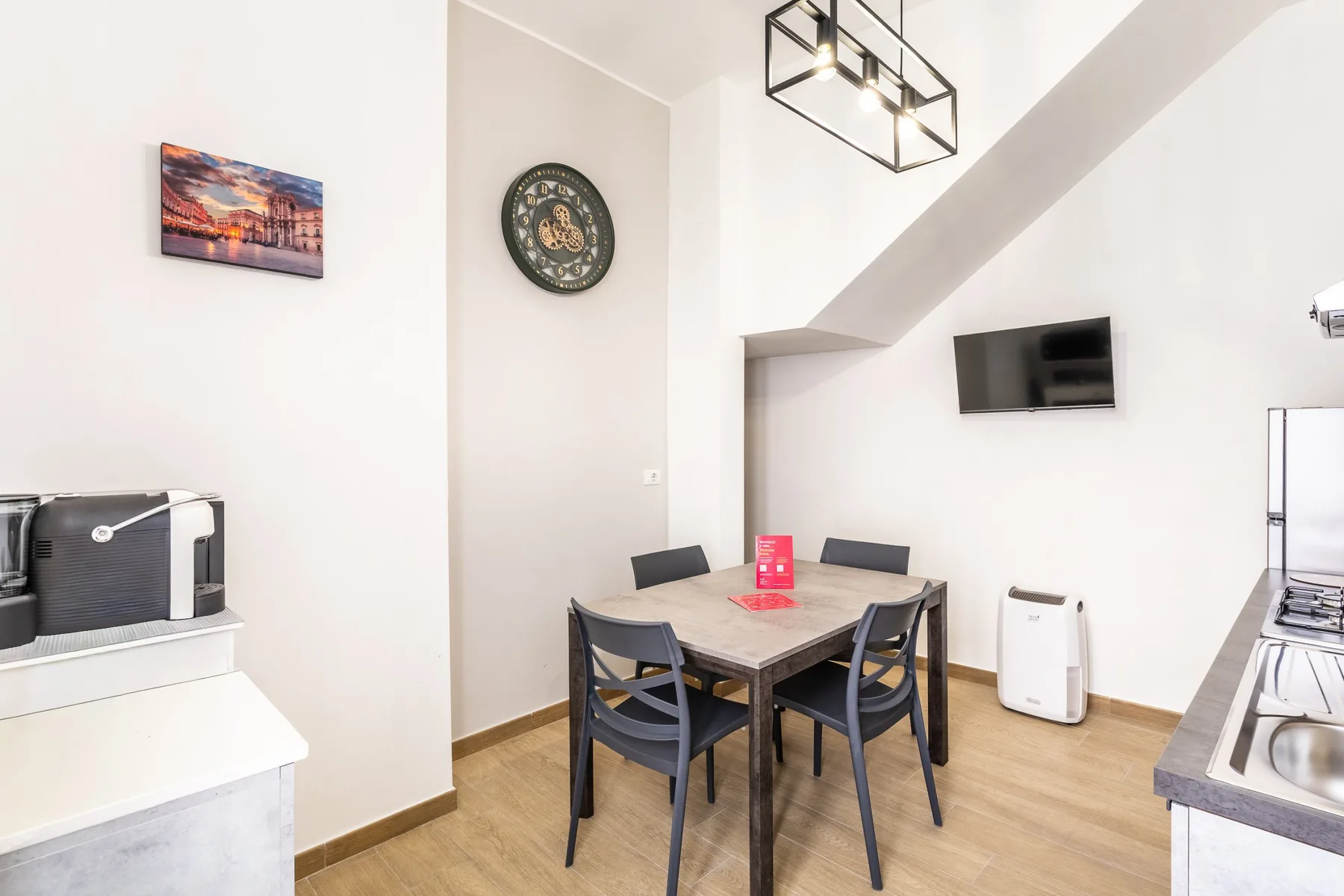 Comedor con una mesa y sillas bajo una lámpara colgante.
