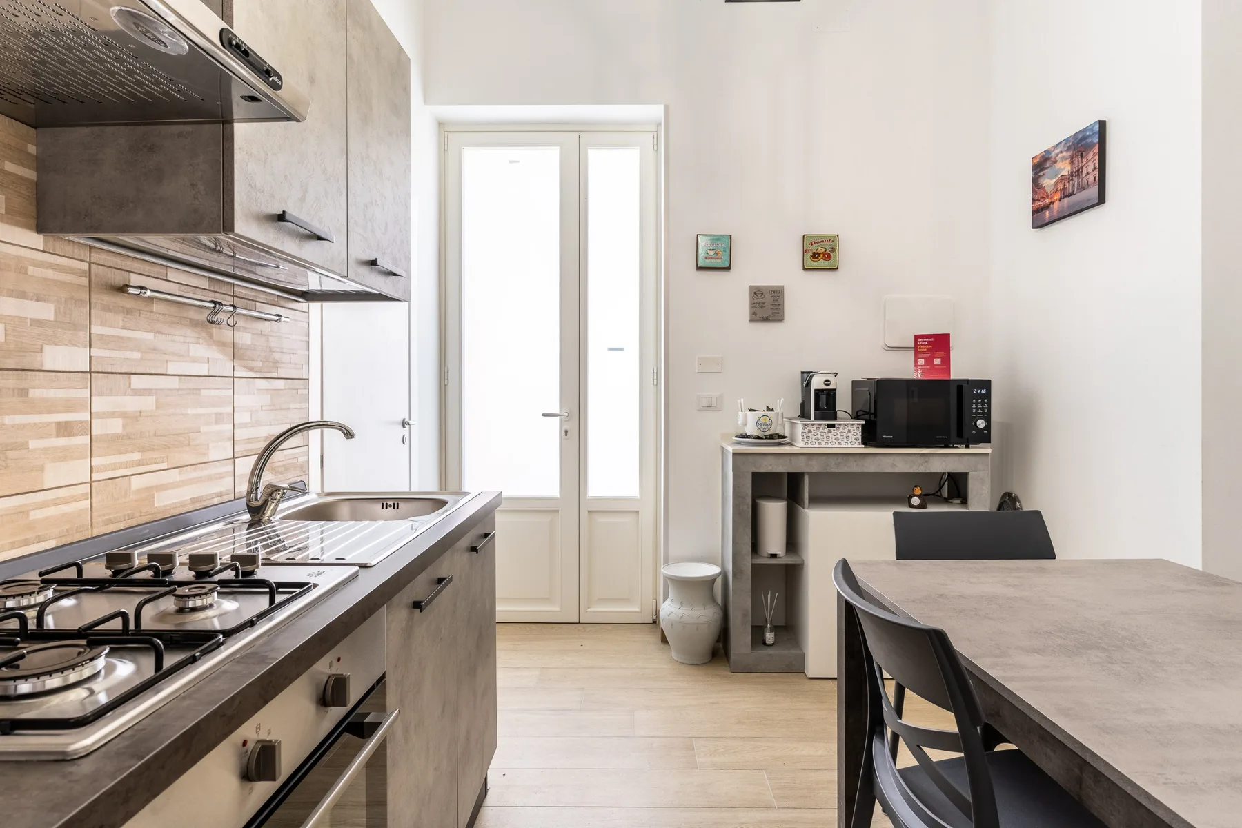 Una cocina y comedor con estufa de gas, fregadero y mesa.