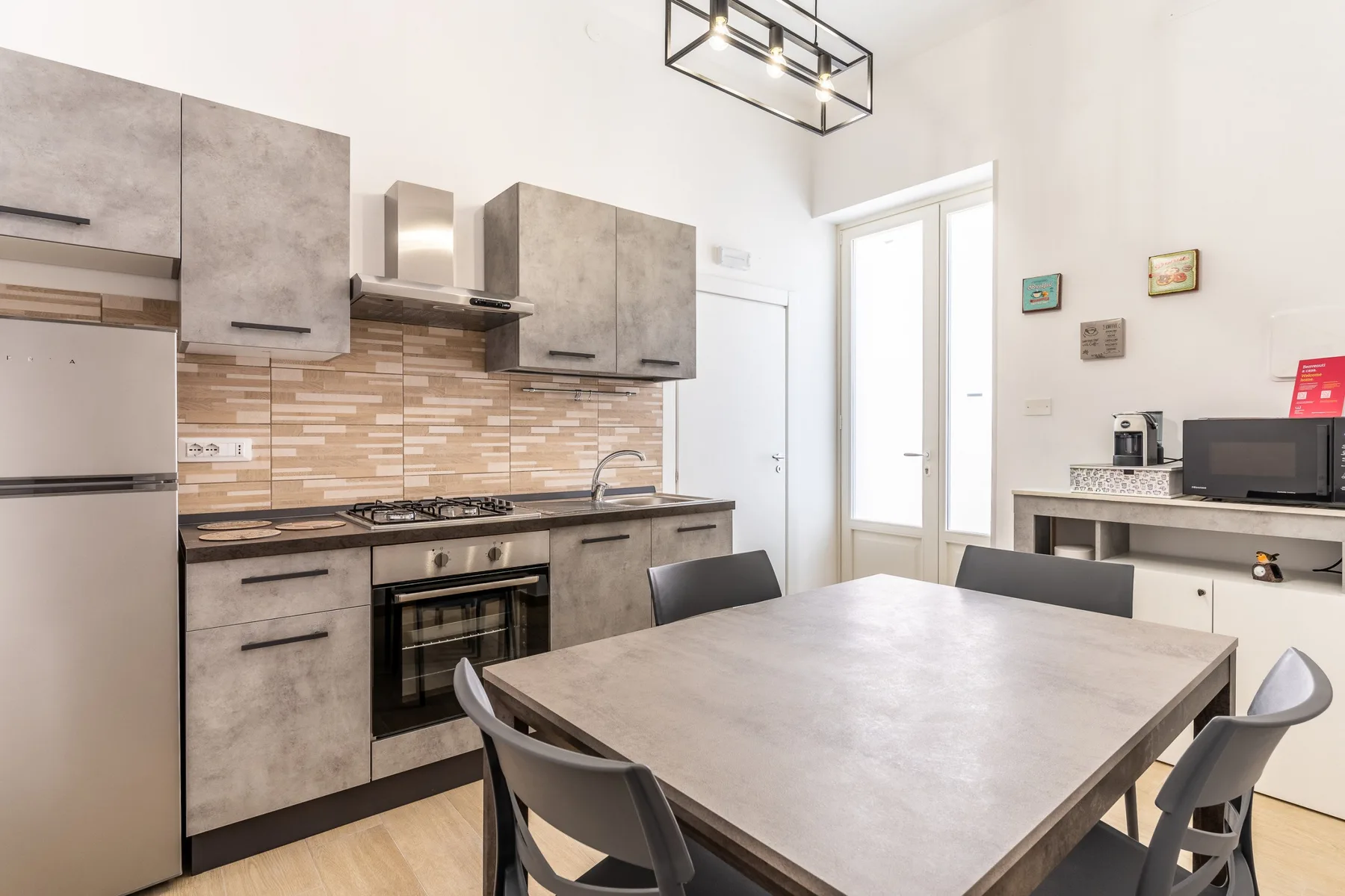 Una cocina y comedor modernos con una mesa grande y gabinetes grises.