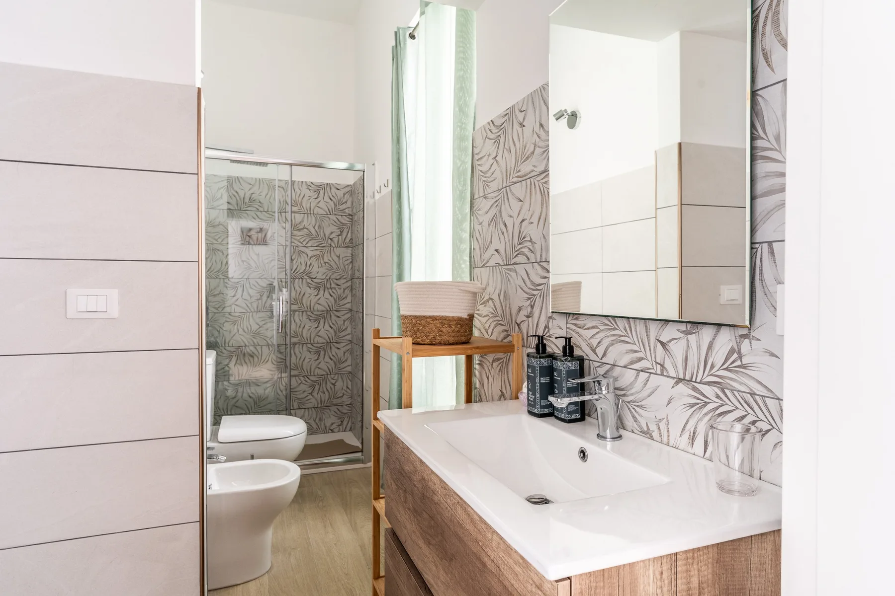 Un baño con lavabo, espejo y ducha con azulejos.