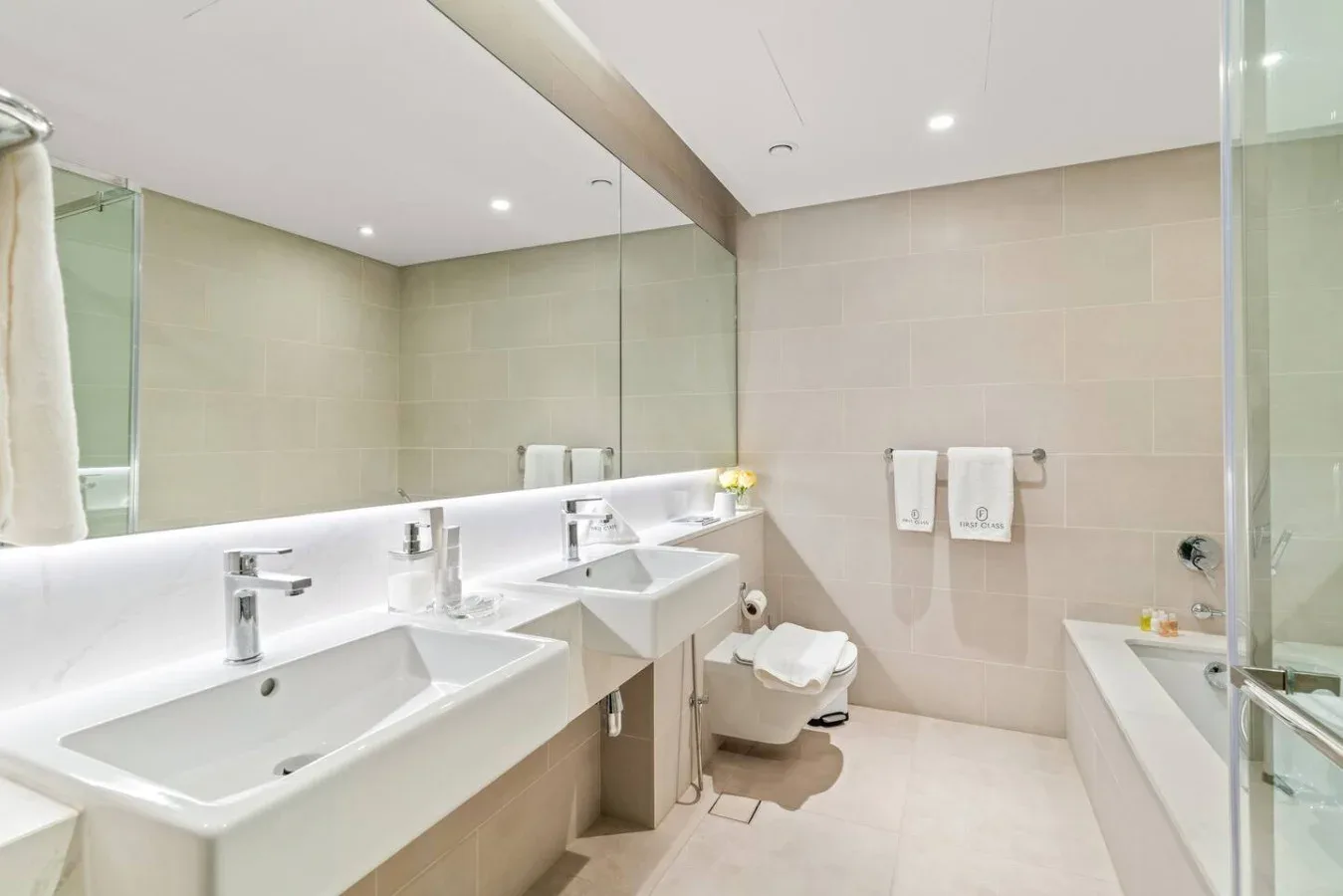 A bright bathroom with a long counter and several sinks.