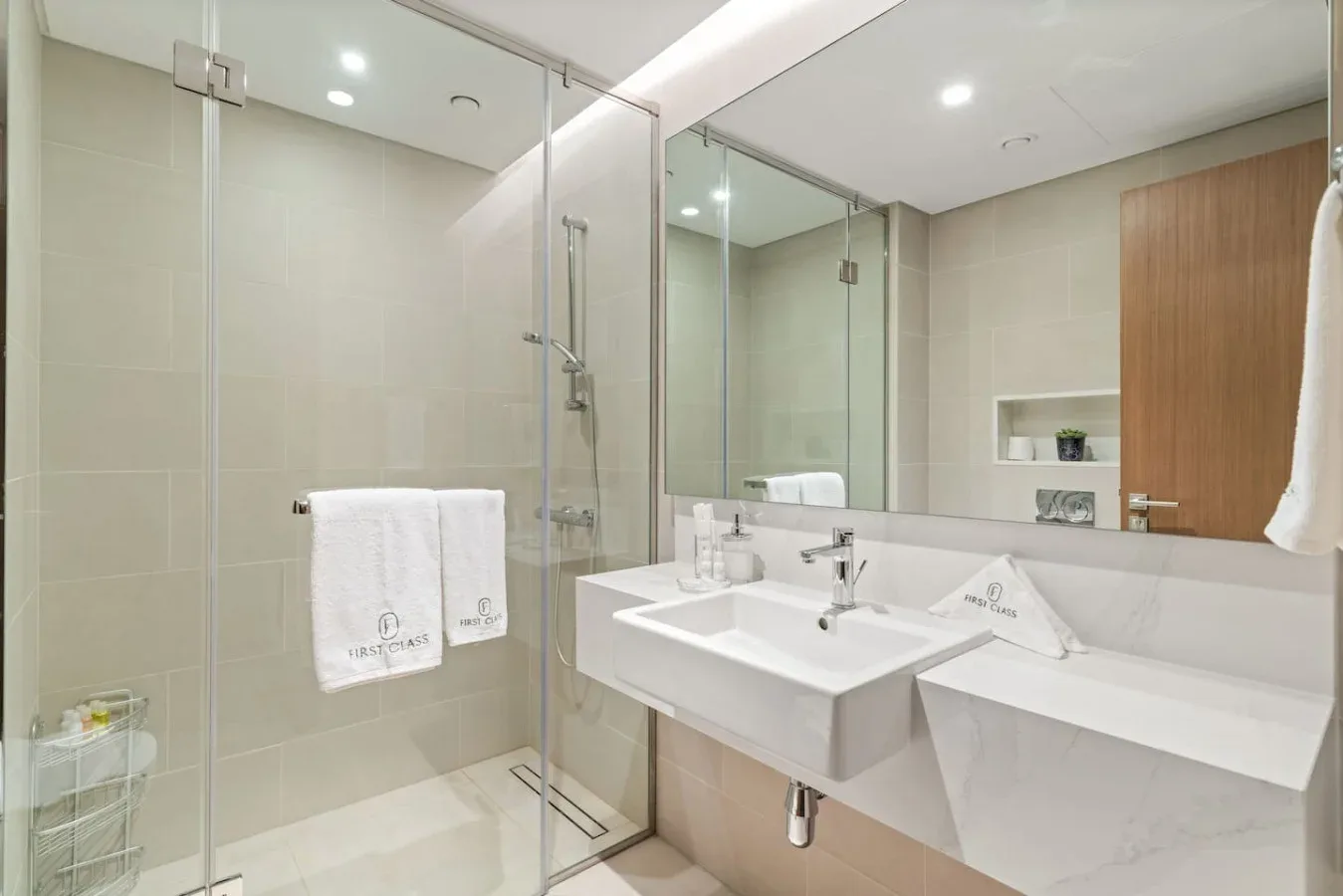 A modern bathroom with a glass shower and two white sinks.