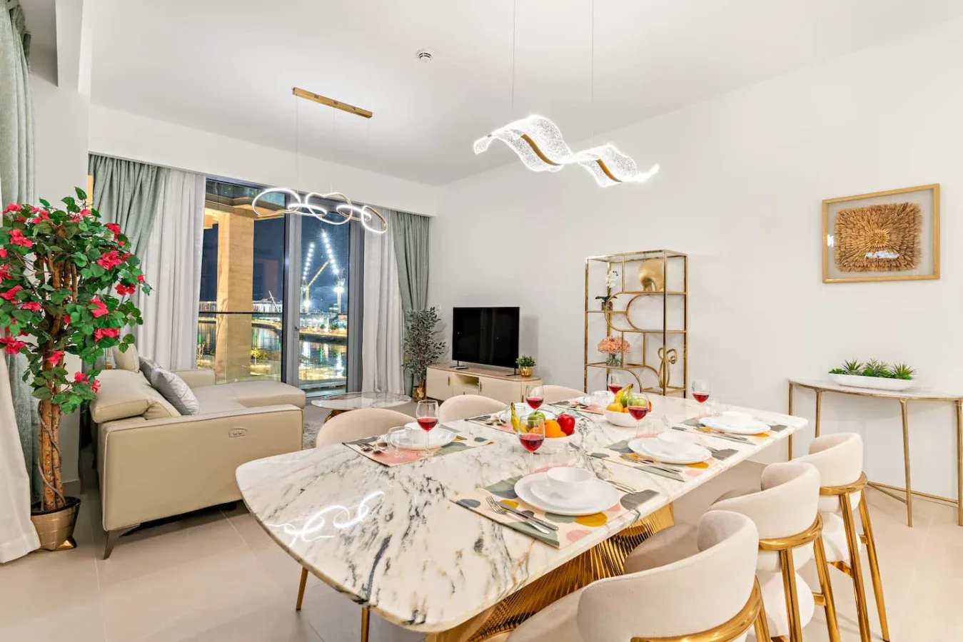 A bright dining and living area features a set dining table and seating.