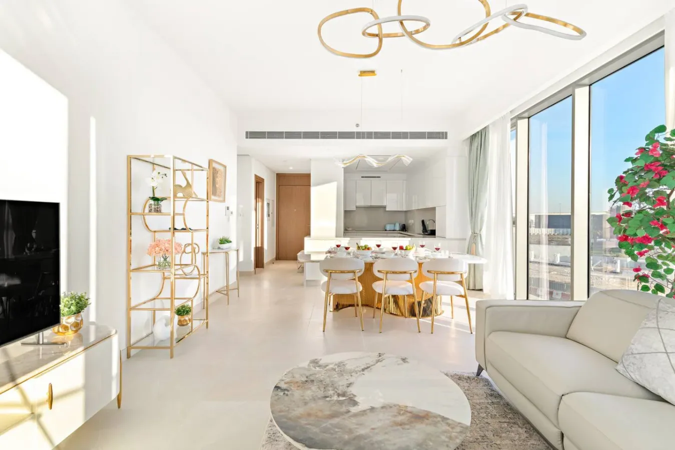 A bright open-plan living and dining area with large windows and a kitchen.