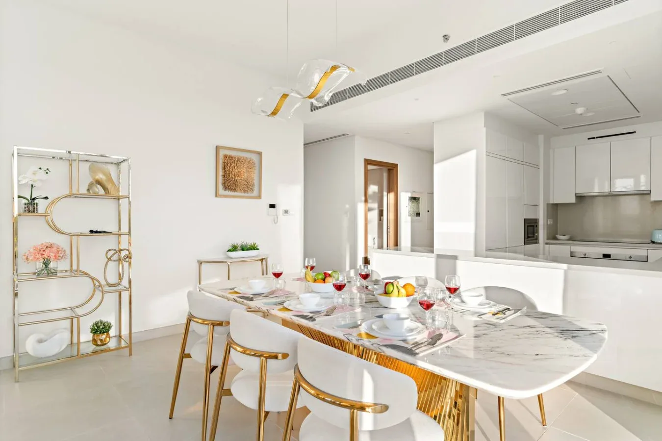A dining area with a set table and an open kitchen in the background.