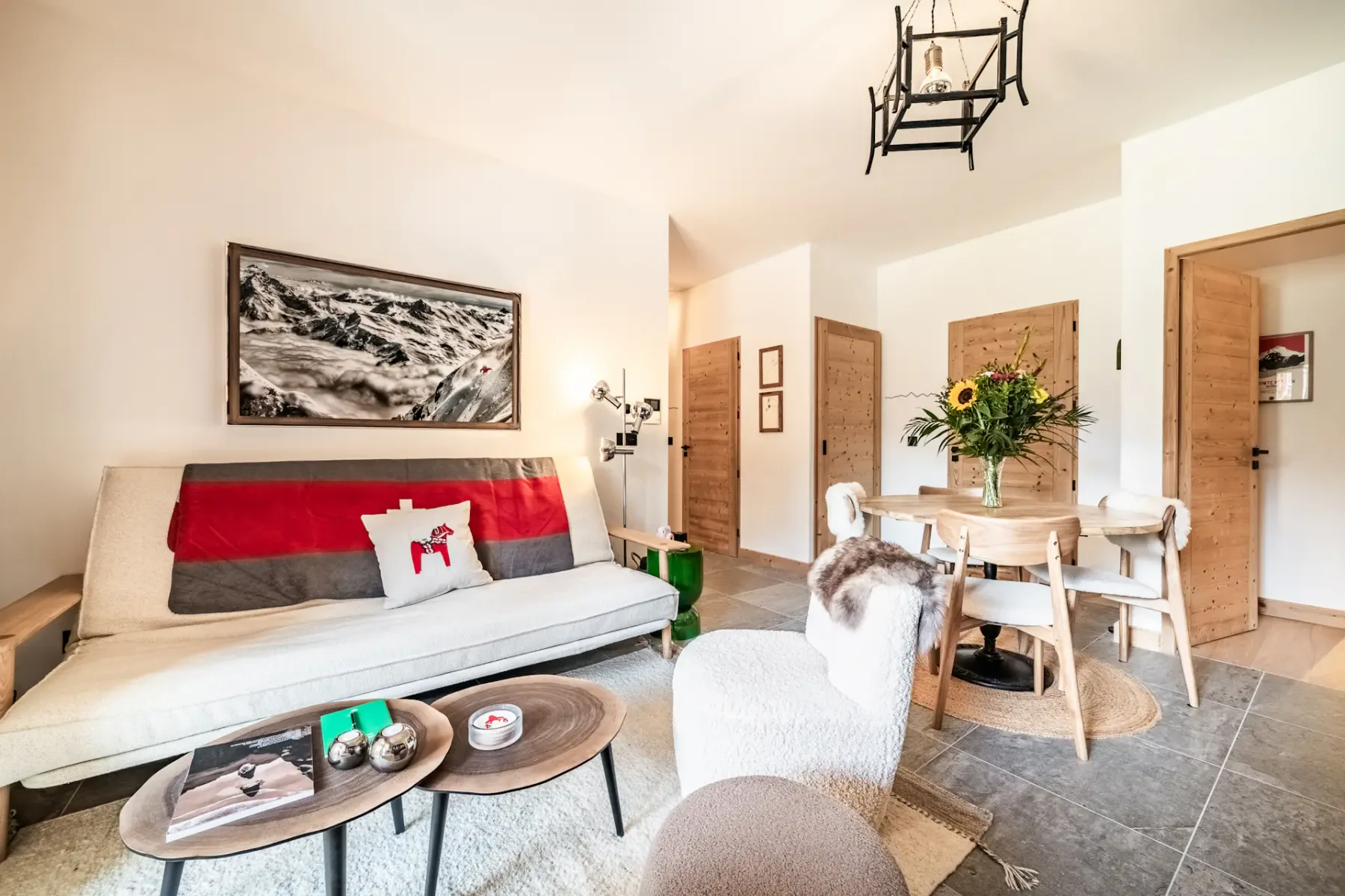 Sala de estar y comedor con un sofá largo y una mesa de comedor de madera.
