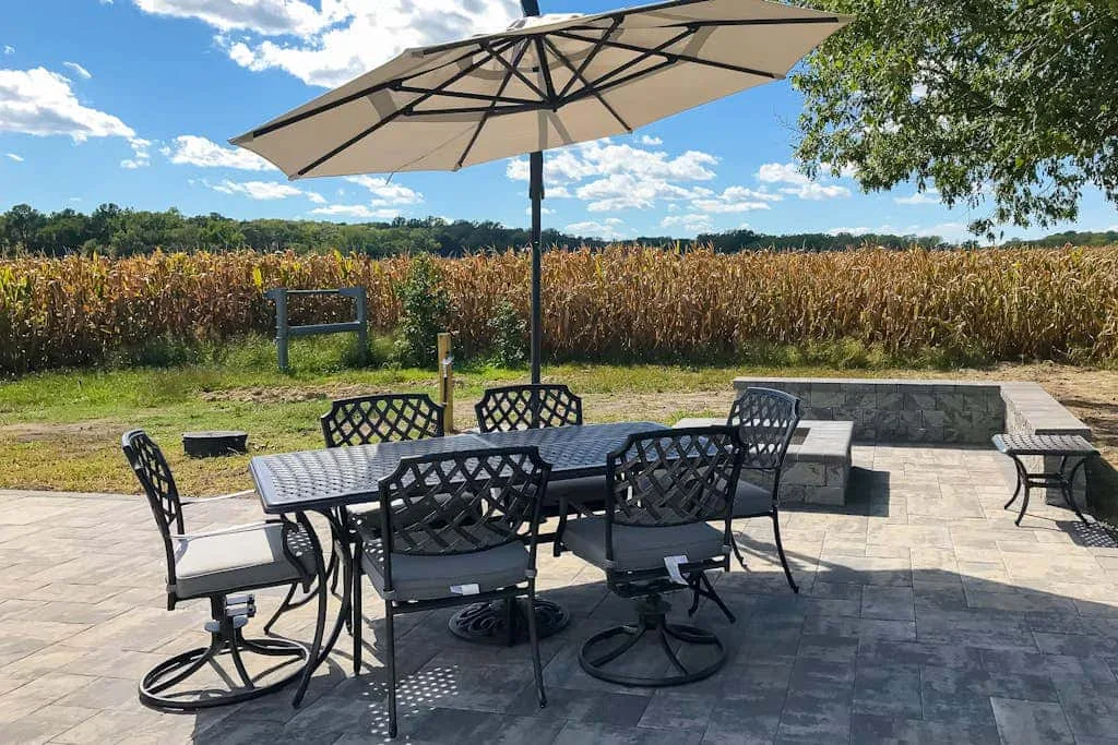 An outdoor patio with a dining table, seating, and a large umbrella.