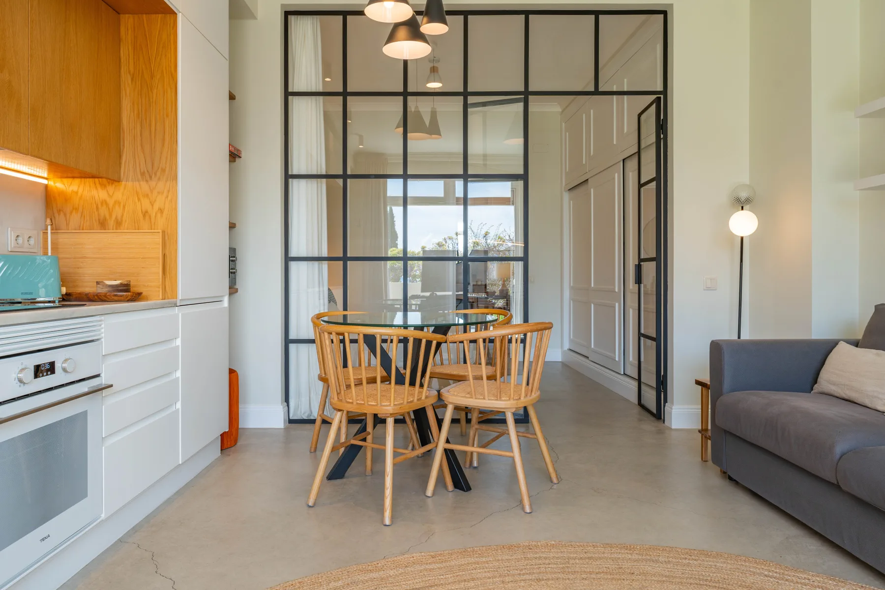Una luminosa sala-comedor de planta abierta con cocina y mesa.