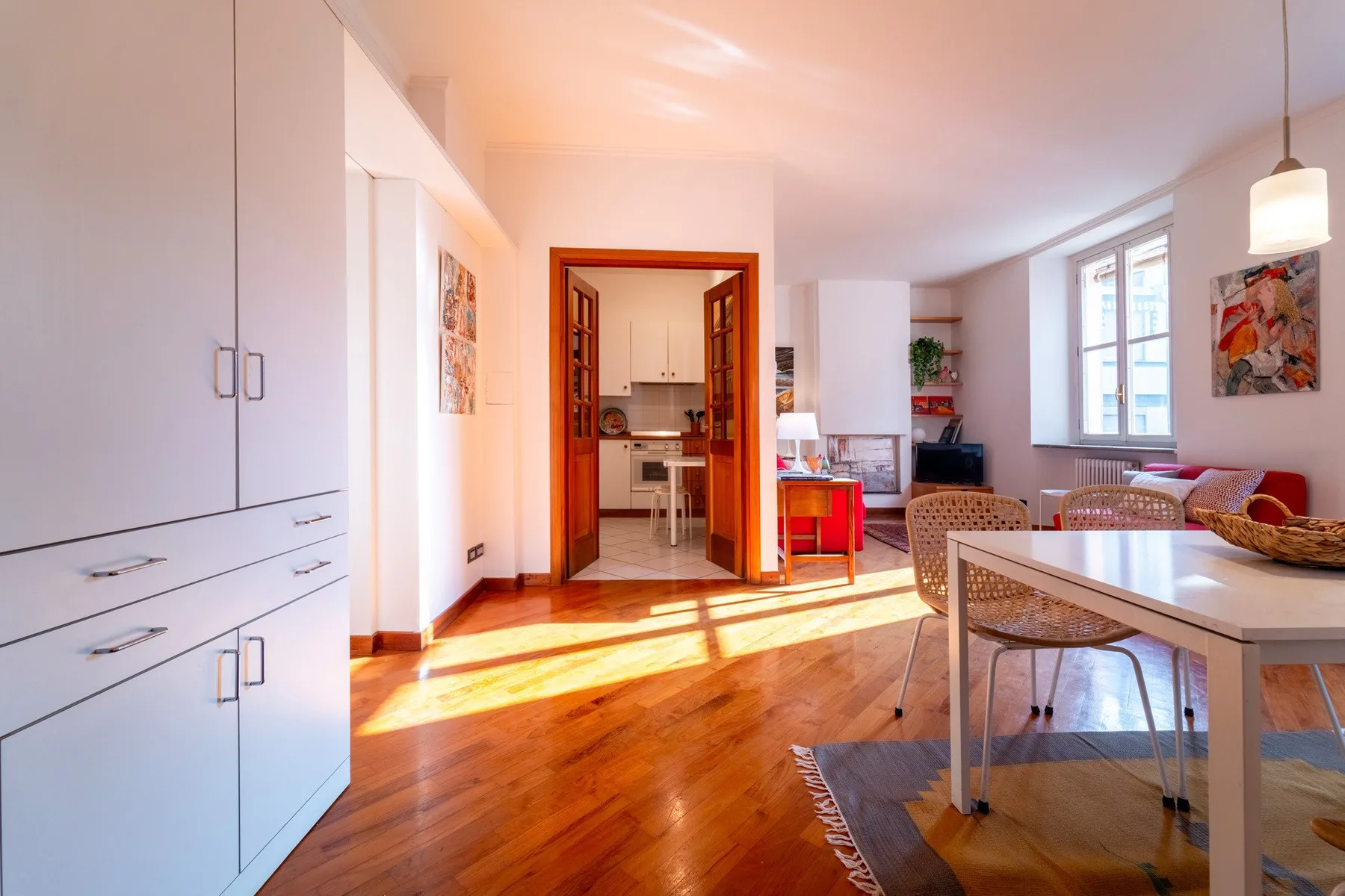 Una luminosa sala-comedor de planta abierta con la cocina al fondo.