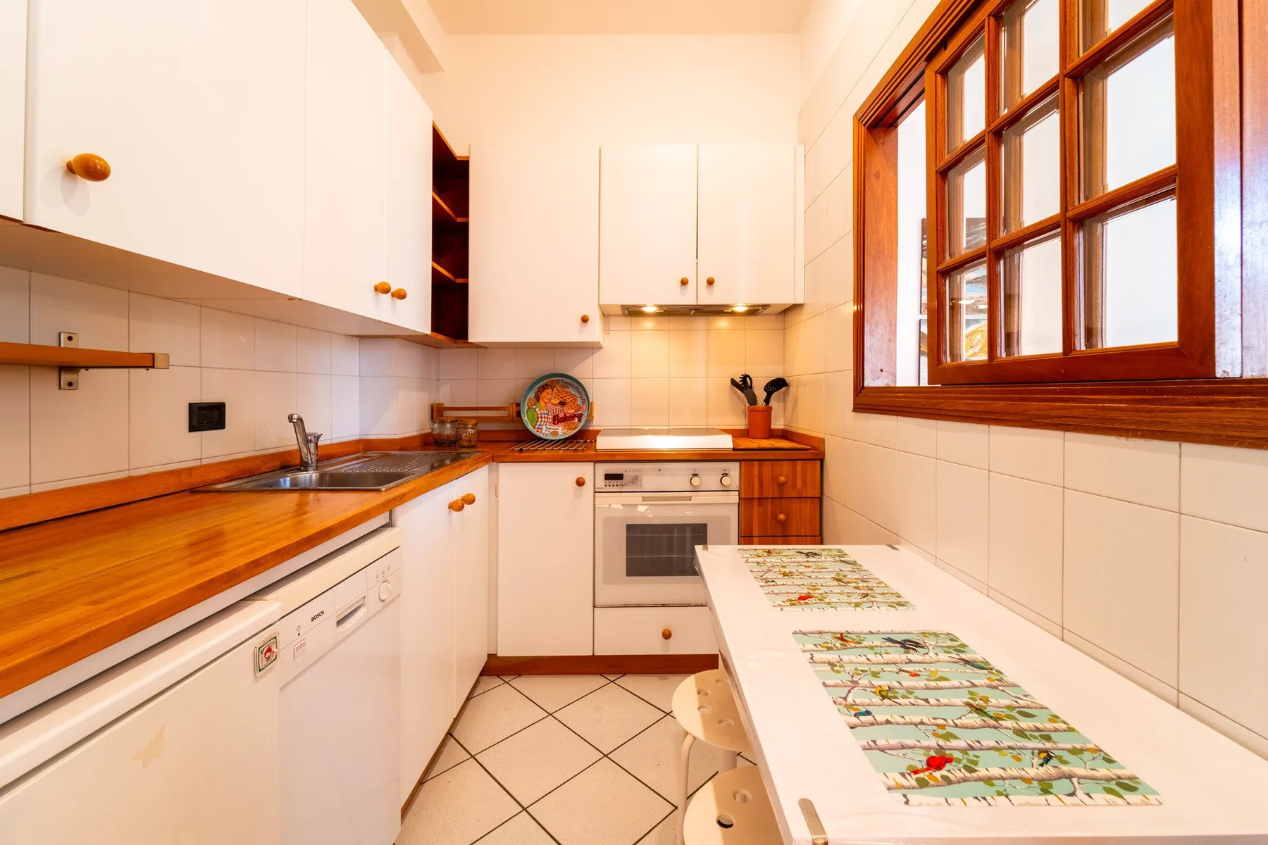 Una cocina luminosa con encimeras de madera y una ventana grande.