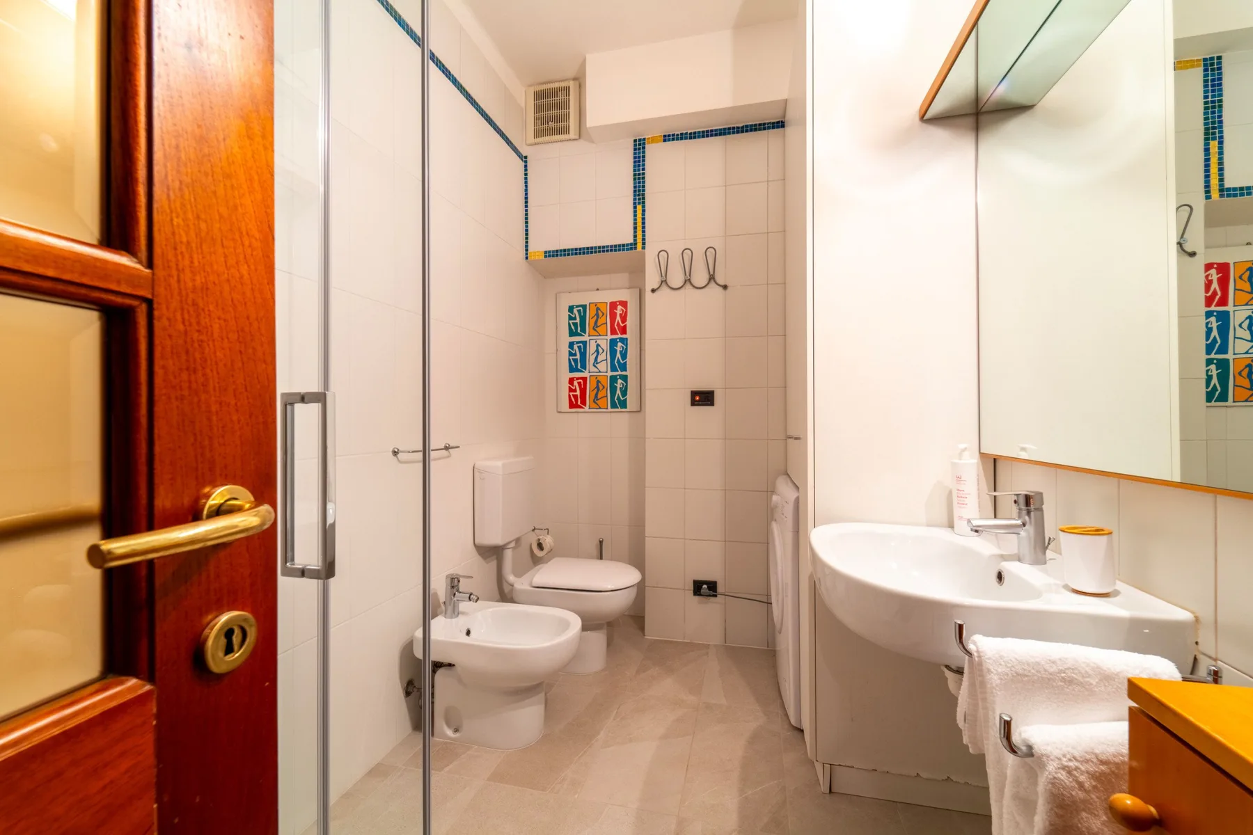Un baño alicatado con ducha, inodoro, bidé y lavabo.