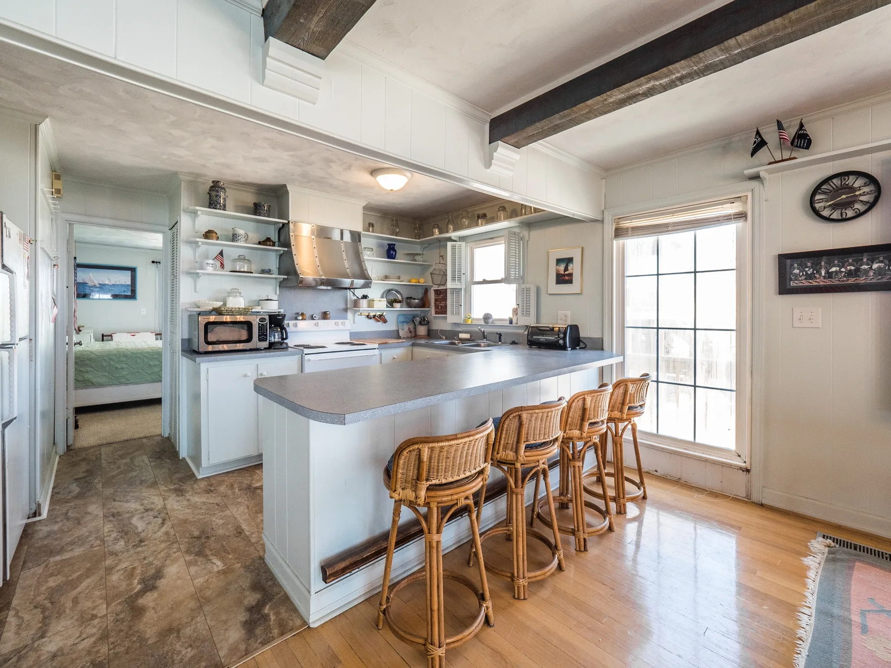 Una cocina luminosa con una isla grande y asientos de barra.