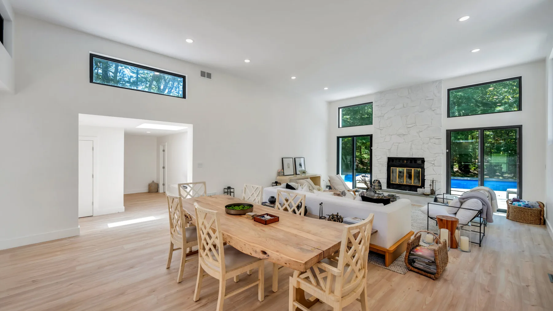 Open-plan dining and living room with a wooden dining table and fireplace.