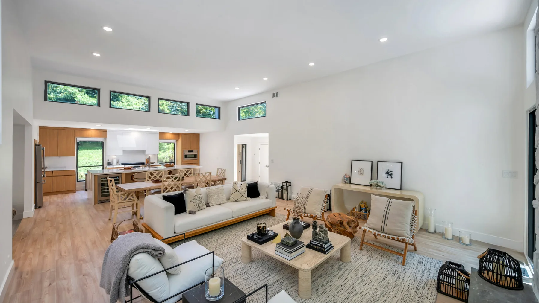 A bright open-plan living room with seating and a dining area.
