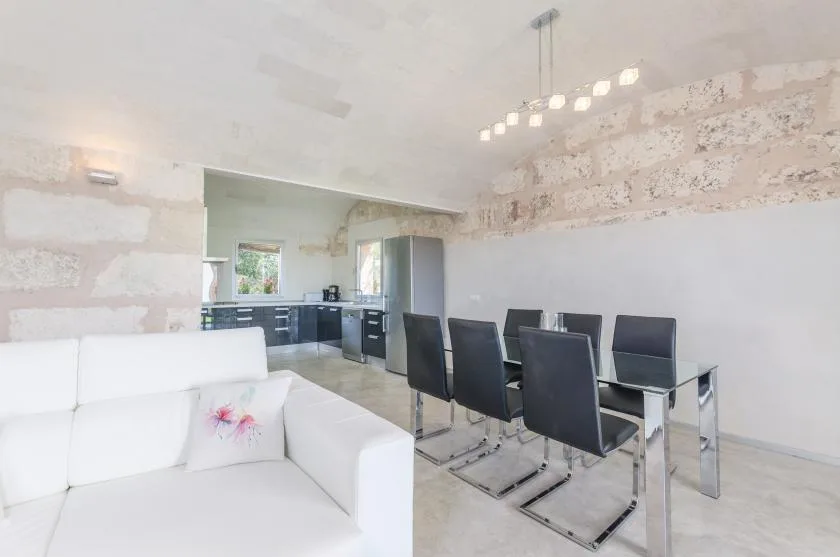 Una luminosa sala-comedor de planta abierta con la cocina al fondo.