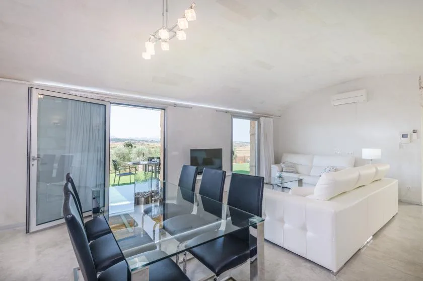 Una luminosa sala de estar y comedor con puertas de vidrio que dan a un patio.