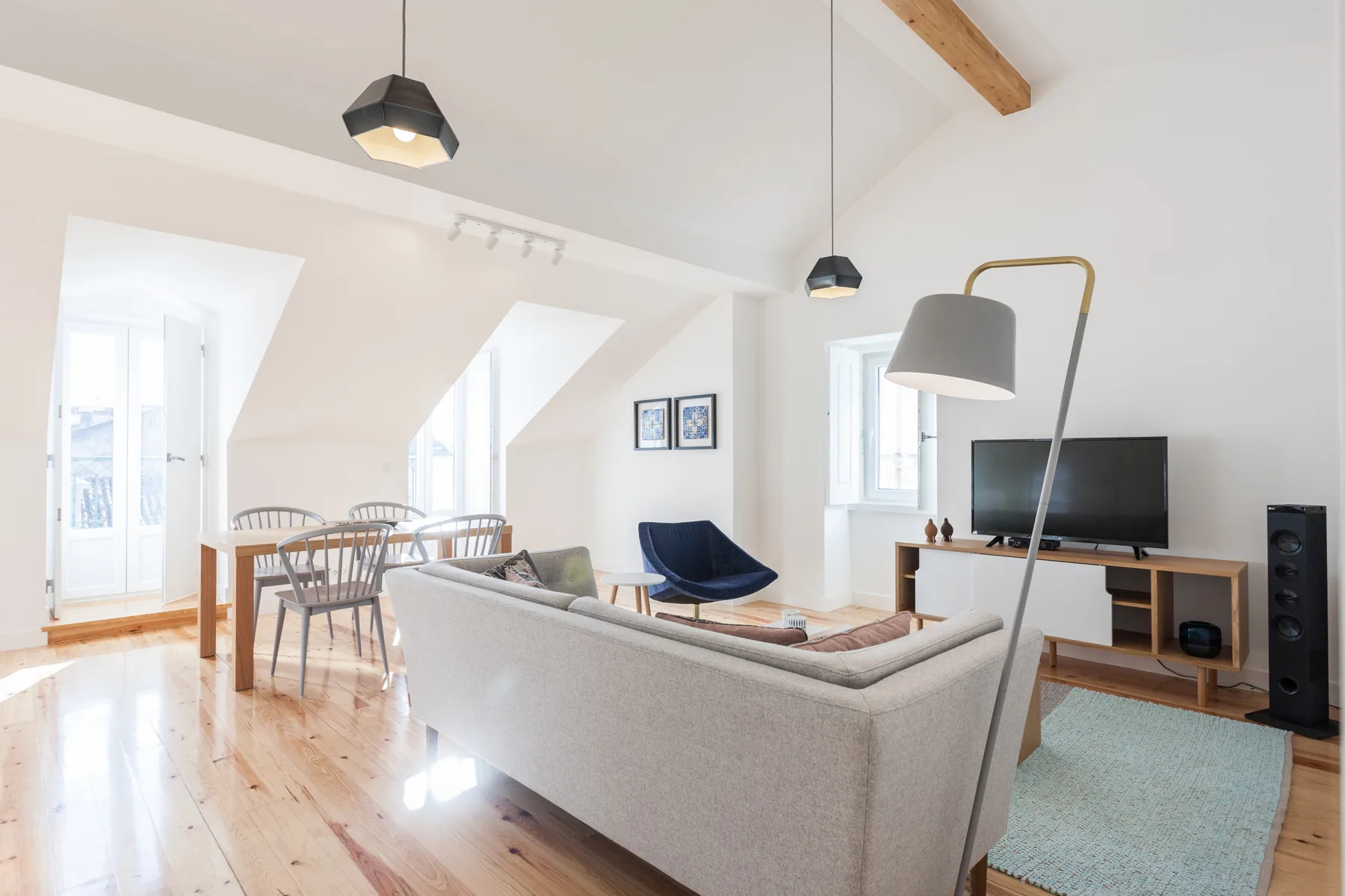 A bright living room with a dining table, seating, and a television.