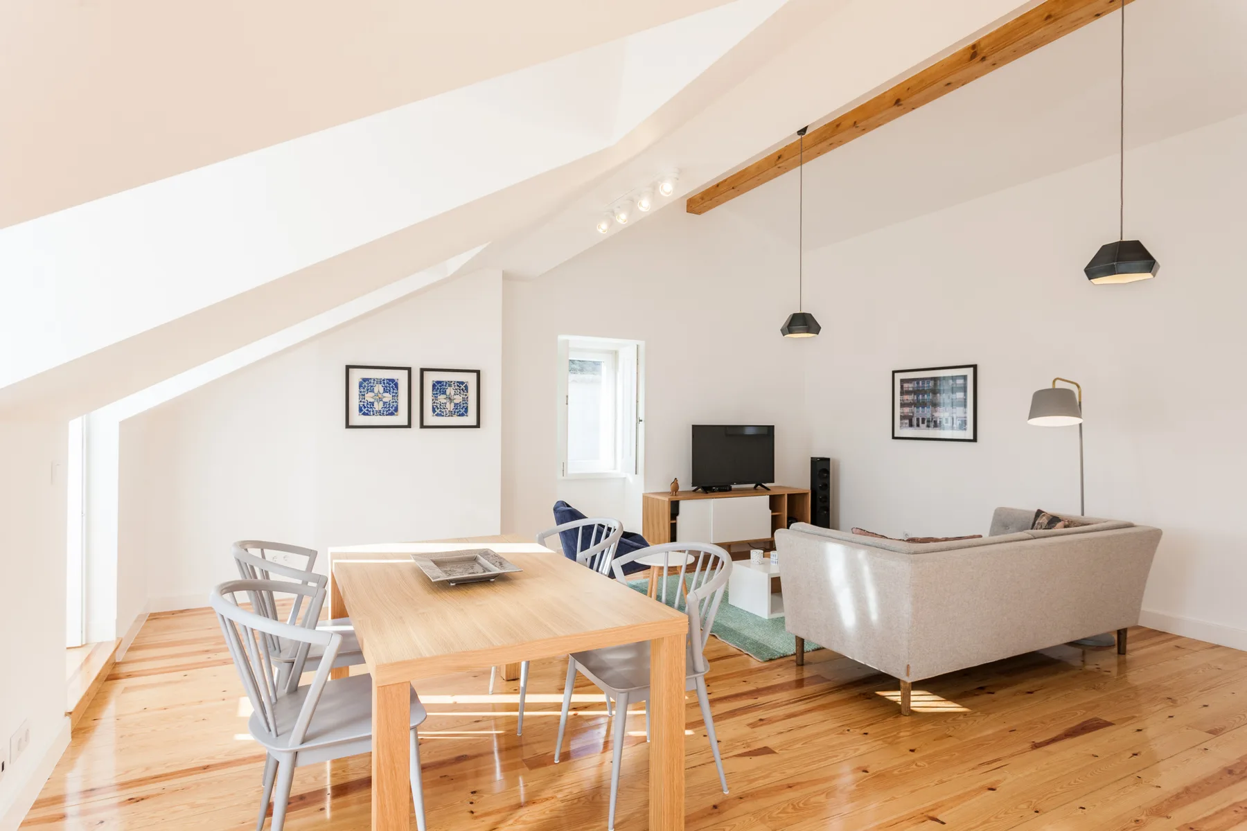 Bright living and dining area with a wooden table and seating.