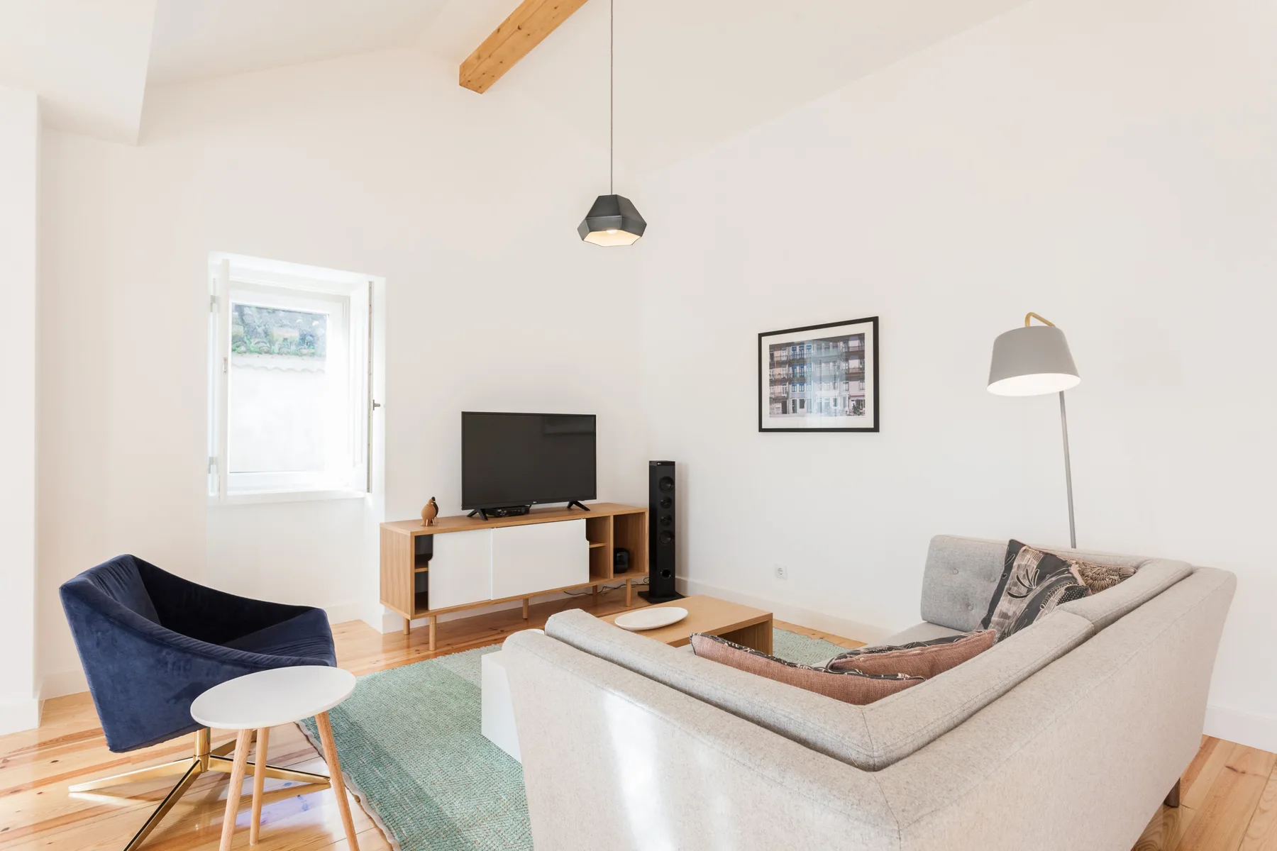A bright living room with seating arranged around a television.