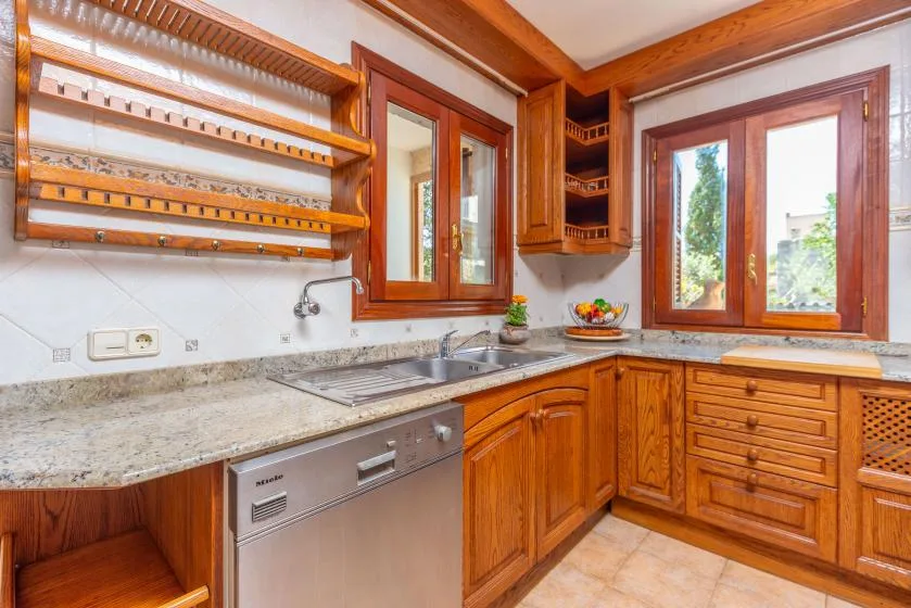 Una cocina equipada con gabinetes de madera, una encimera y una ventana.