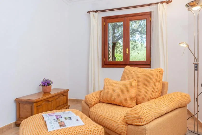 Una sala de estar con asientos naranjas bajo una ventana.