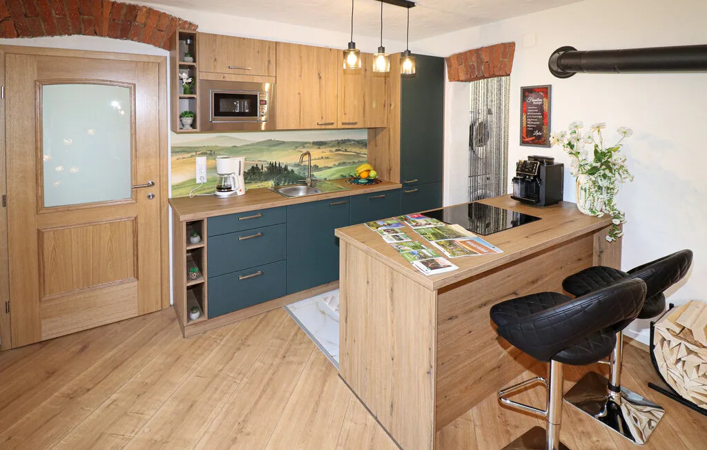 Una cocina con una isla de acabado de madera y gabinetes oscuros.