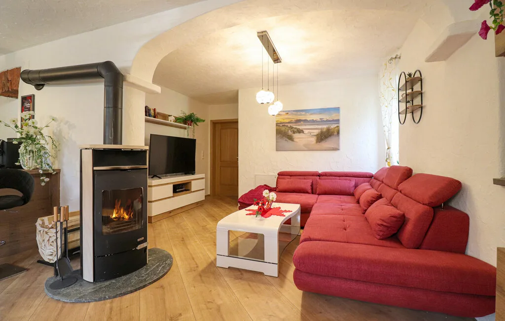 Una sala de estar con asientos rojos, una mesa de centro y una chimenea.
