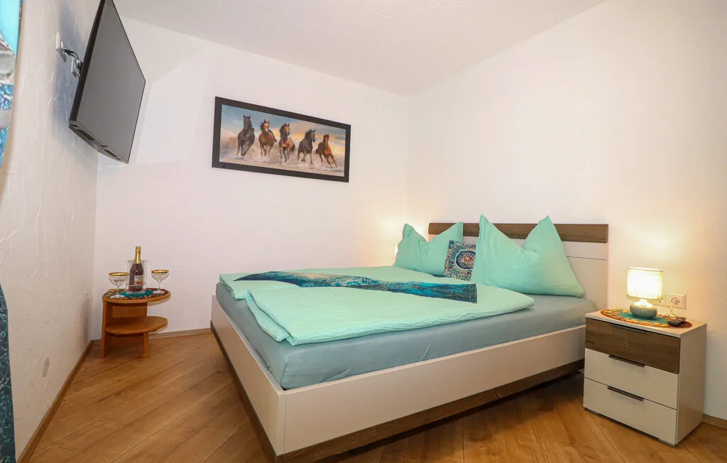 Un dormitorio con una cama tendida y un cuadro enmarcado en la pared.