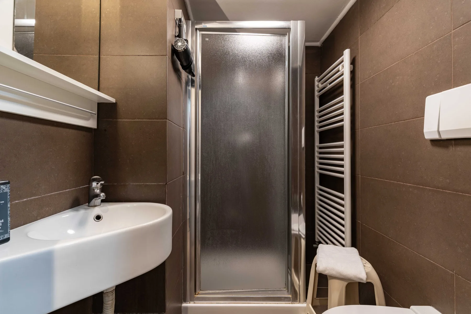 A tiled bathroom with a sink and glass shower.