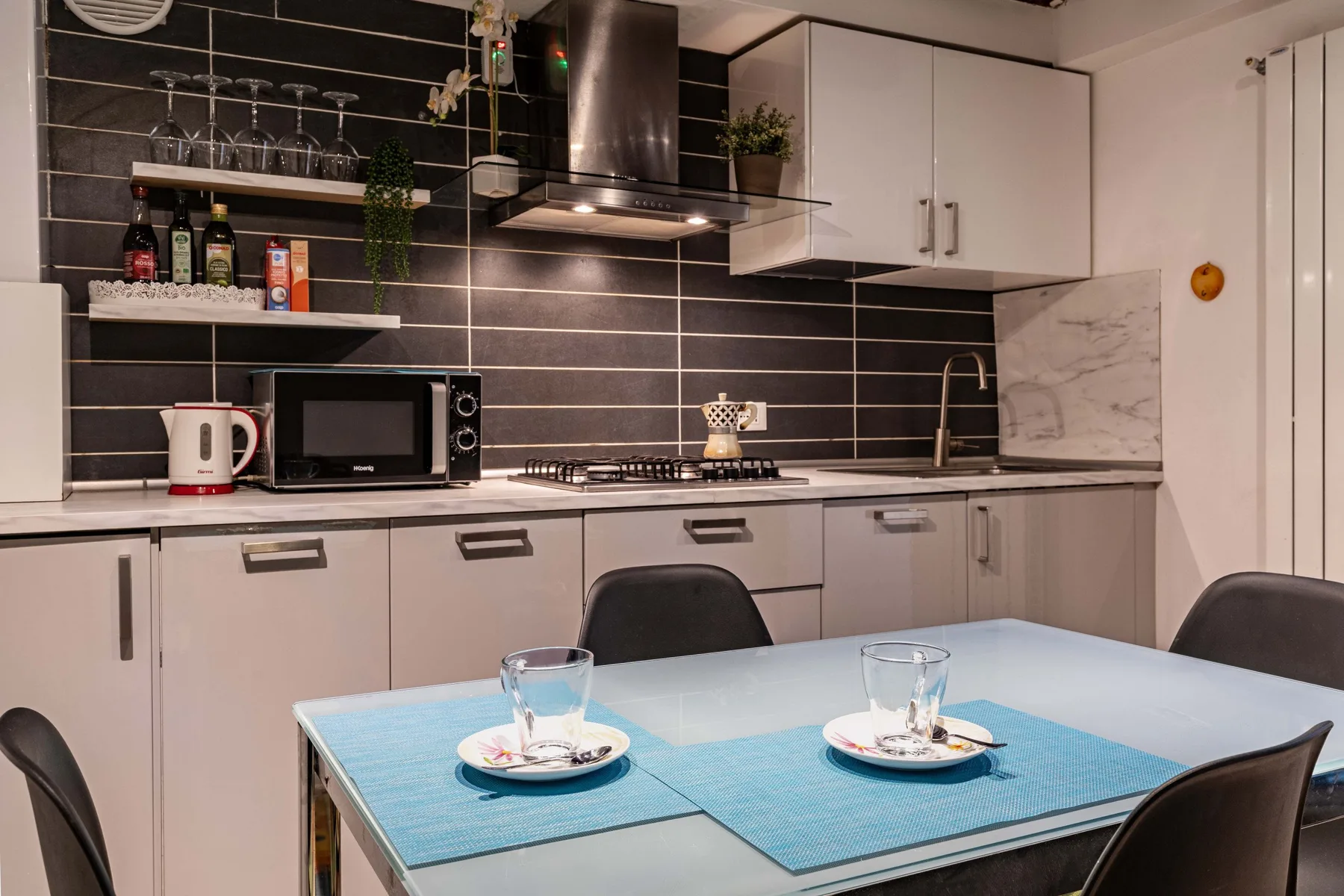 Una cocina moderna con una mesa de comedor puesta para dos personas.