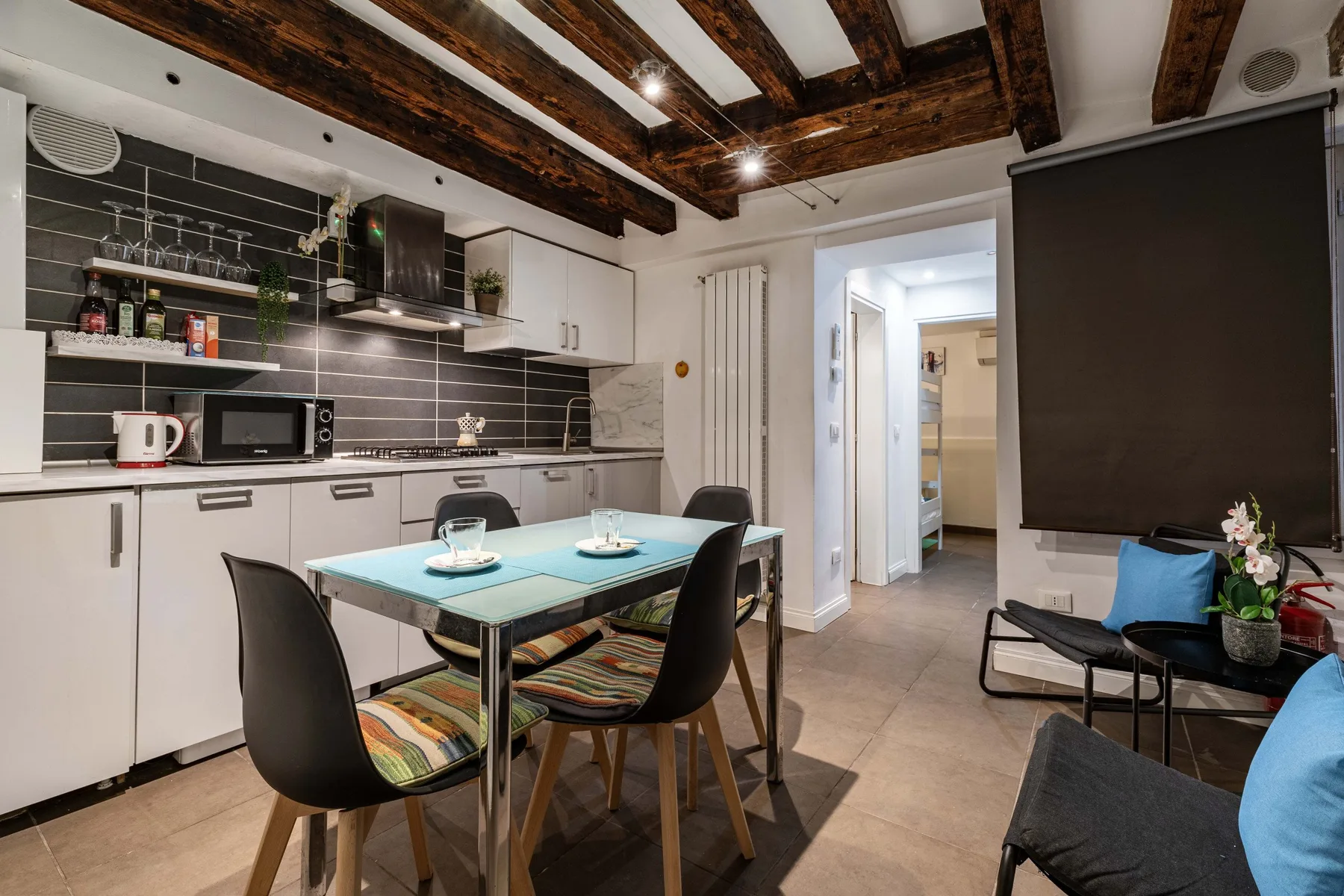 A kitchen and dining area with a table, seating, and white cabinets.