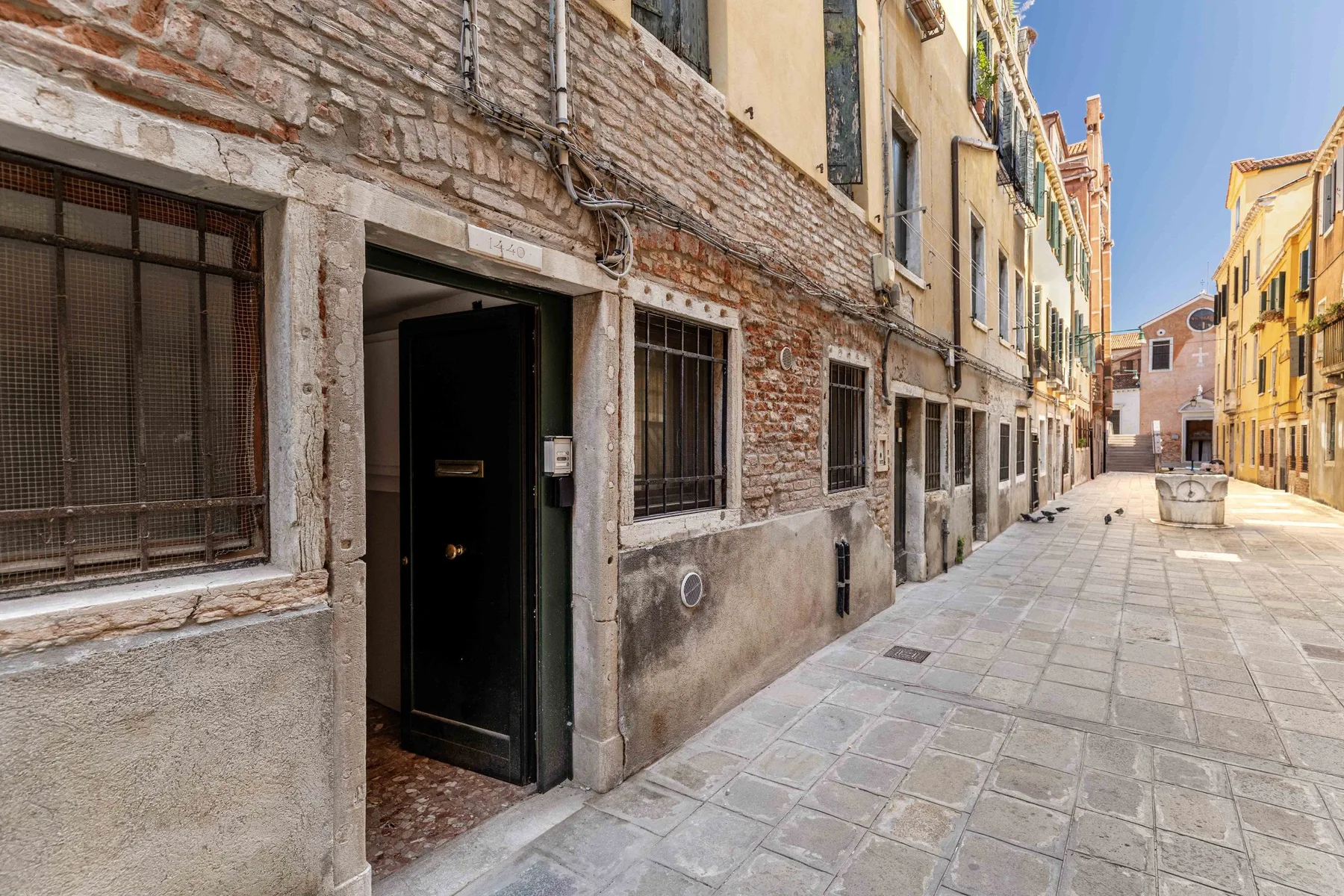A narrow paved street runs between closely spaced buildings.