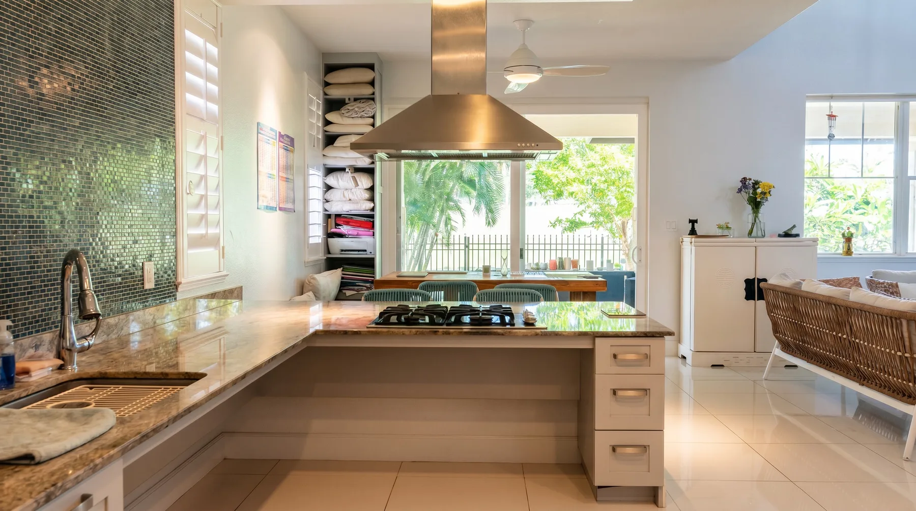 Una cocina luminosa con una isla central y un comedor junto a las ventanas.
