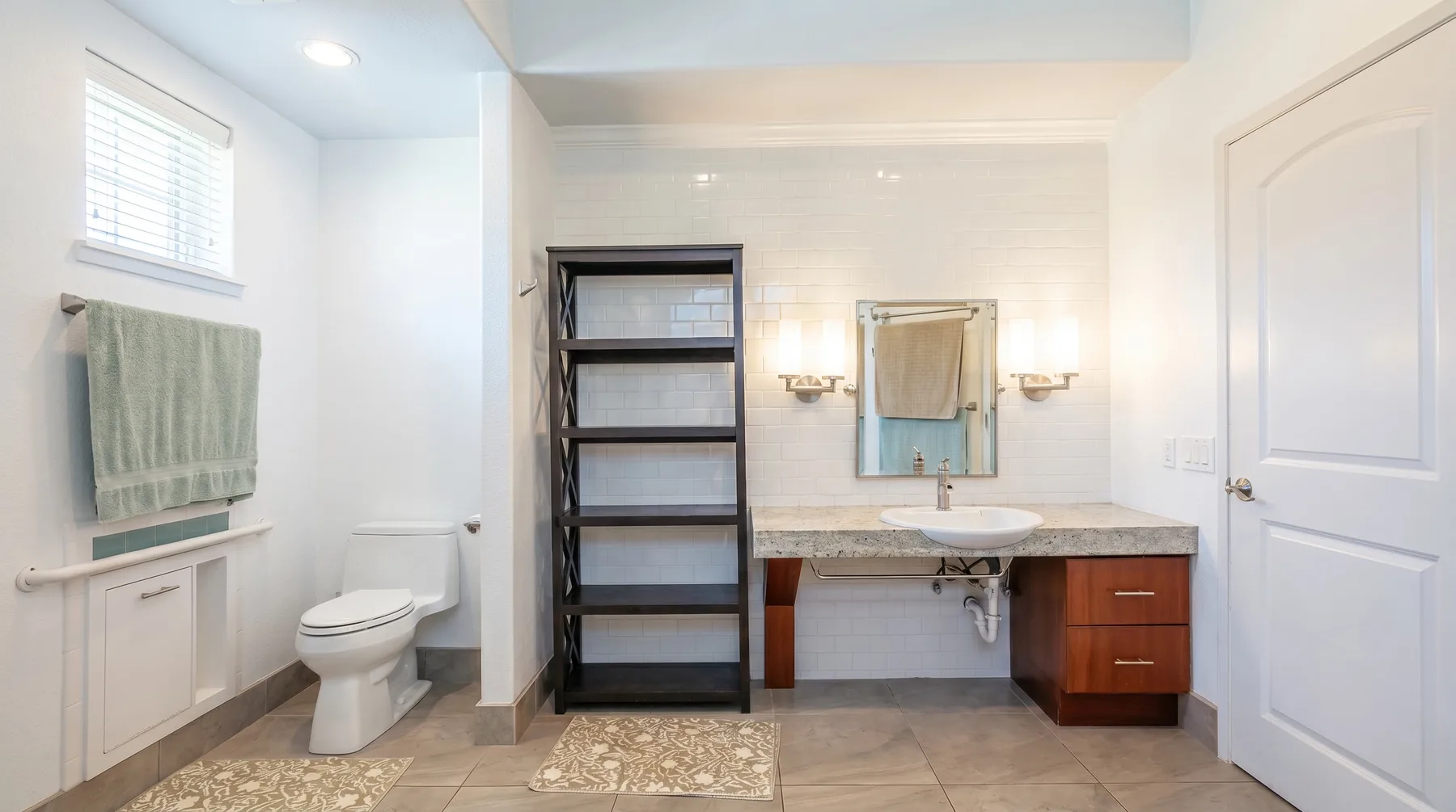 Un baño luminoso con lavabo, inodoro y estanterías abiertas.