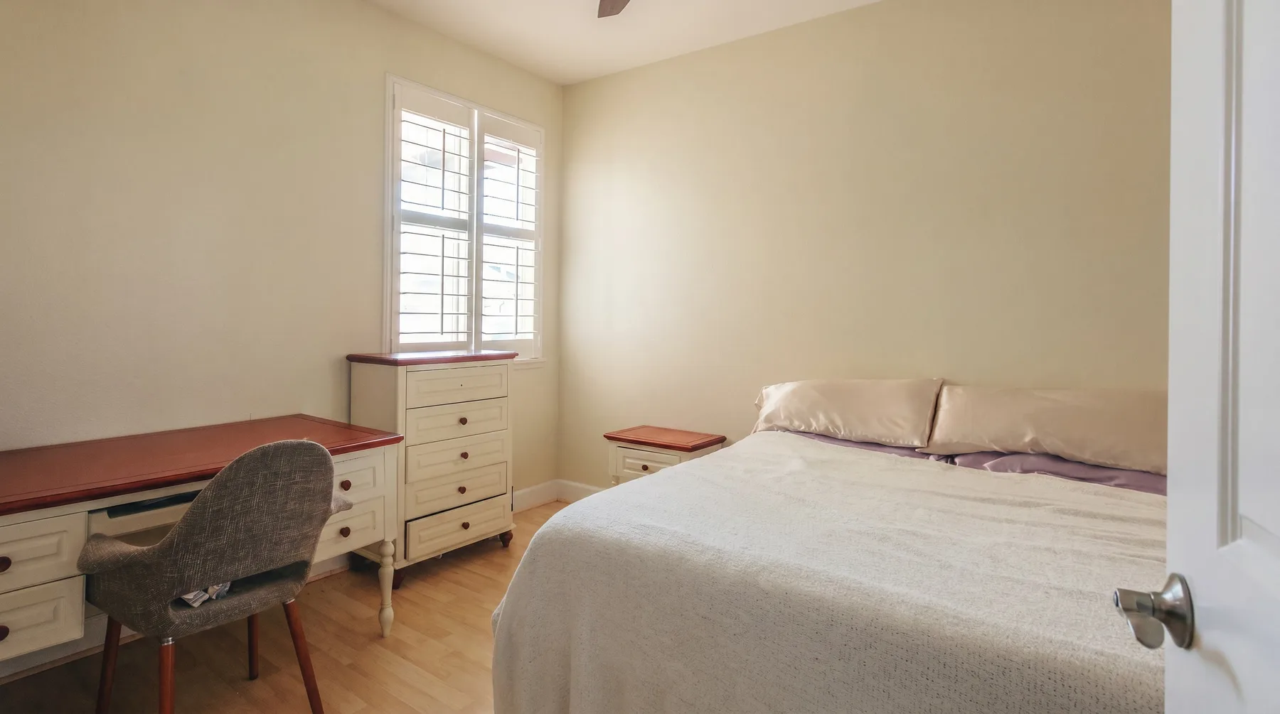 Un dormitorio con una cama, un escritorio y una ventana.