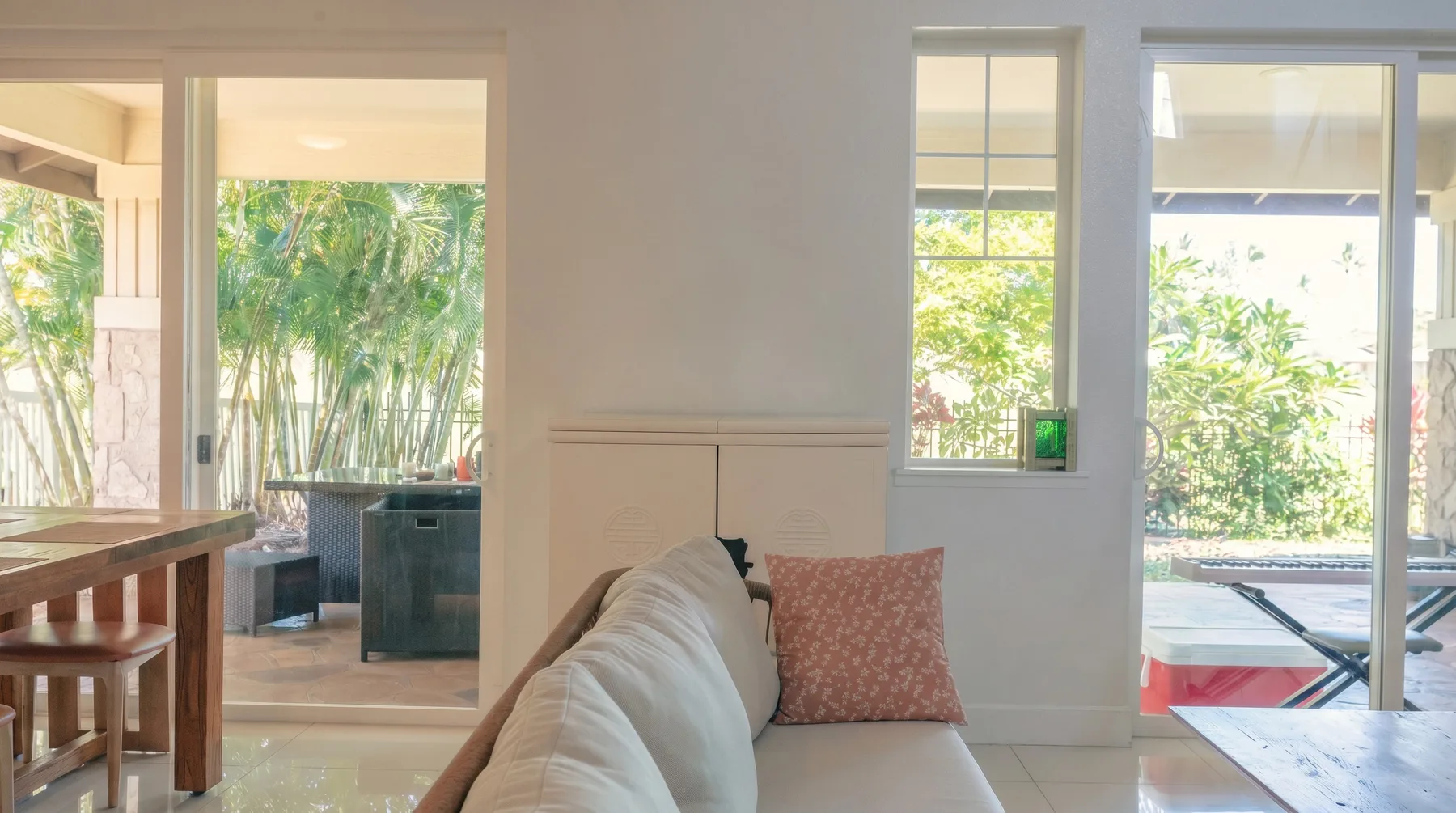 Una sala luminosa con asientos junto a grandes ventanas con vistas a la vegetación.