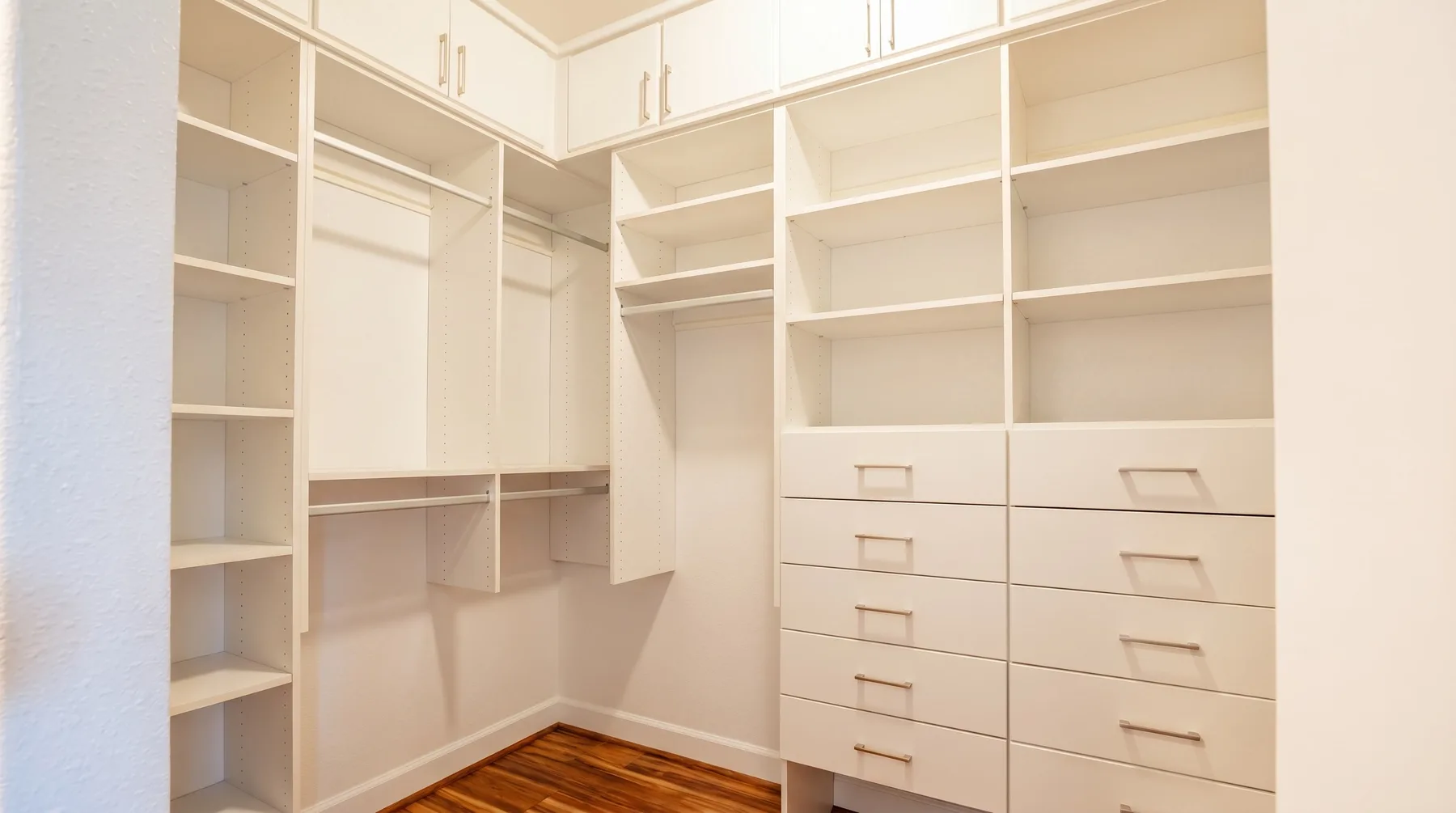 Un vestidor con estantes empotrados, espacio para colgar ropa y cajones.