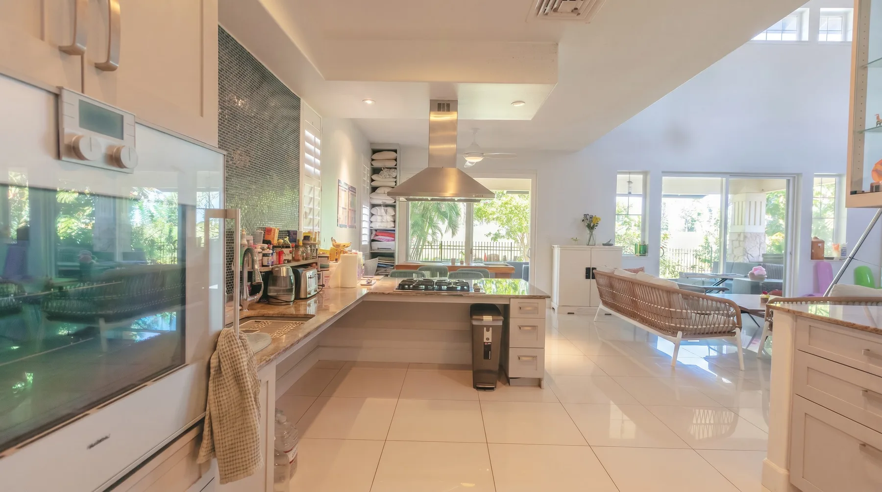 Una cocina luminosa de planta abierta con comedor y ventanas grandes.