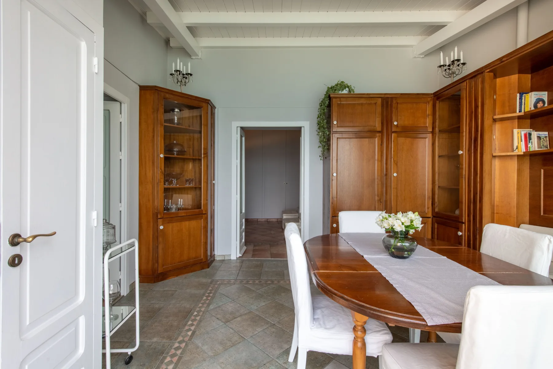 A dining room with a wooden table and built-in shelving.