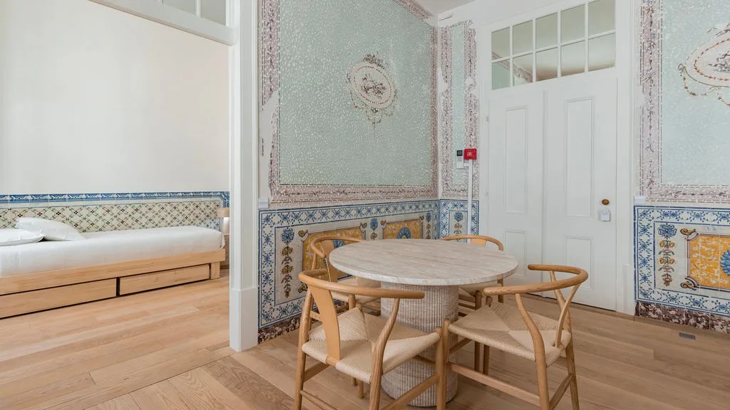 Un comedor con una mesa redonda y sillas junto a un banco empotrado.