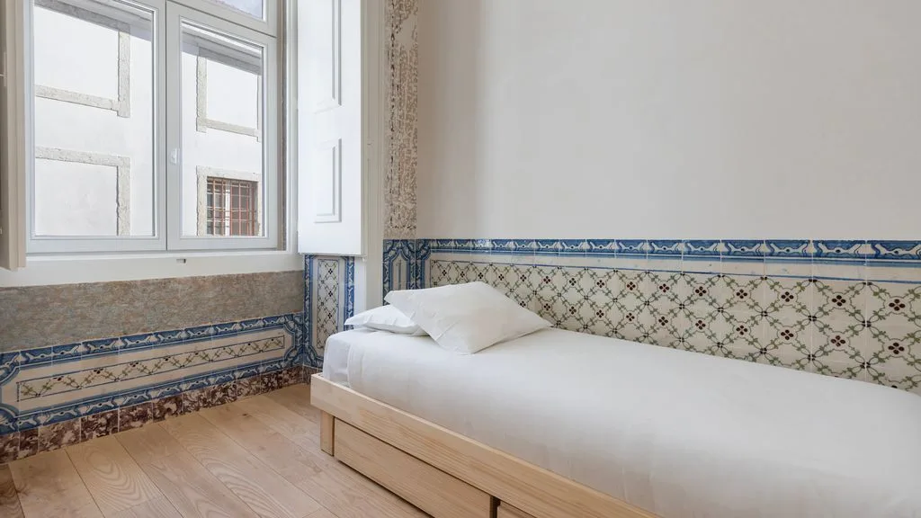 Un dormitorio con una cama junto a una ventana grande.